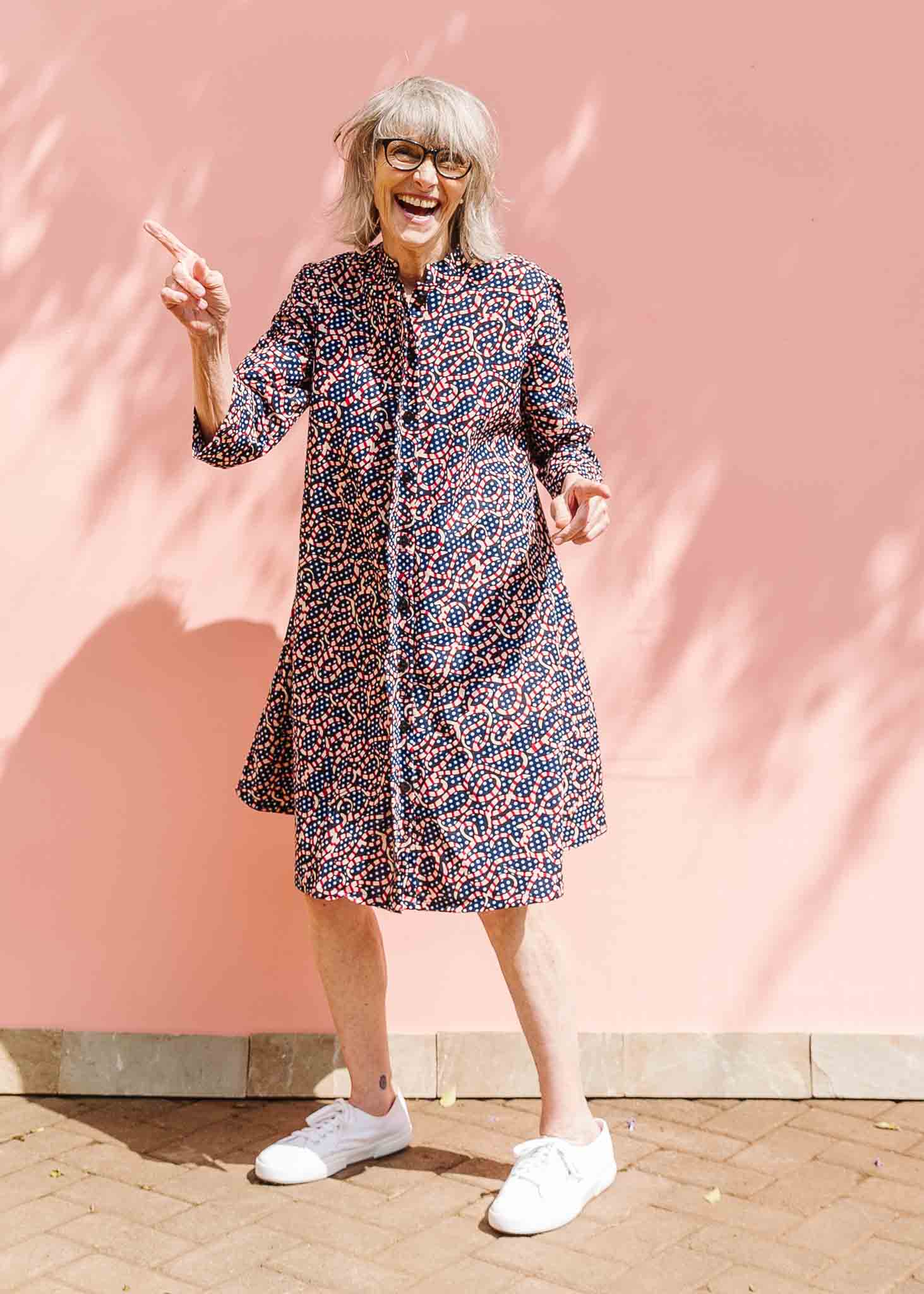 Model wearing blue and red ribbon print dress.