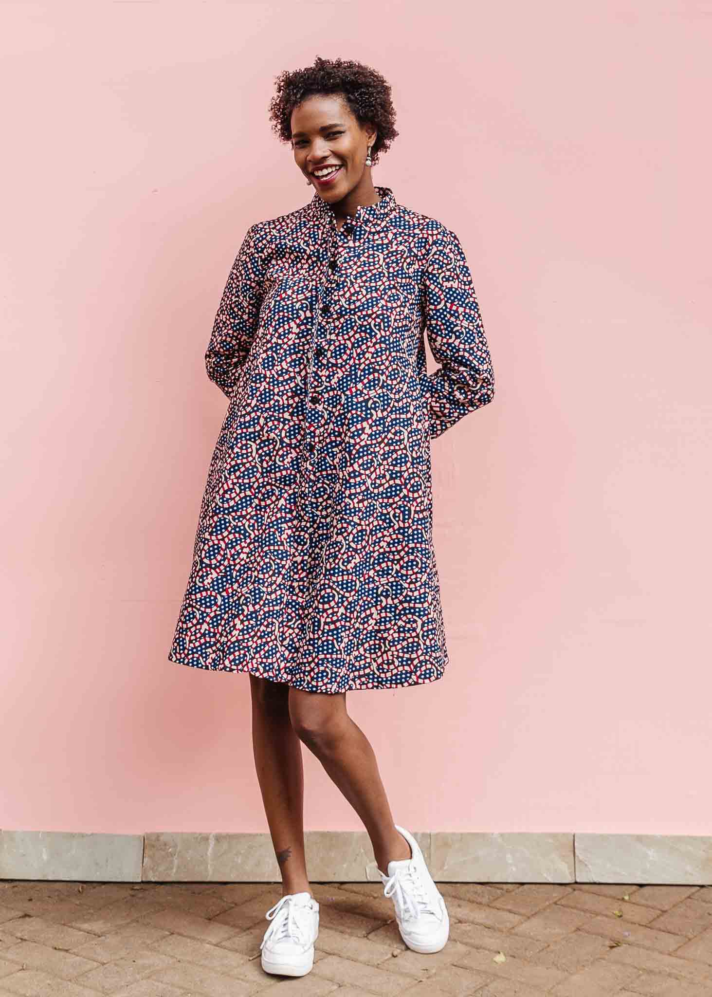 Model wearing blue and red ribbon print dress.