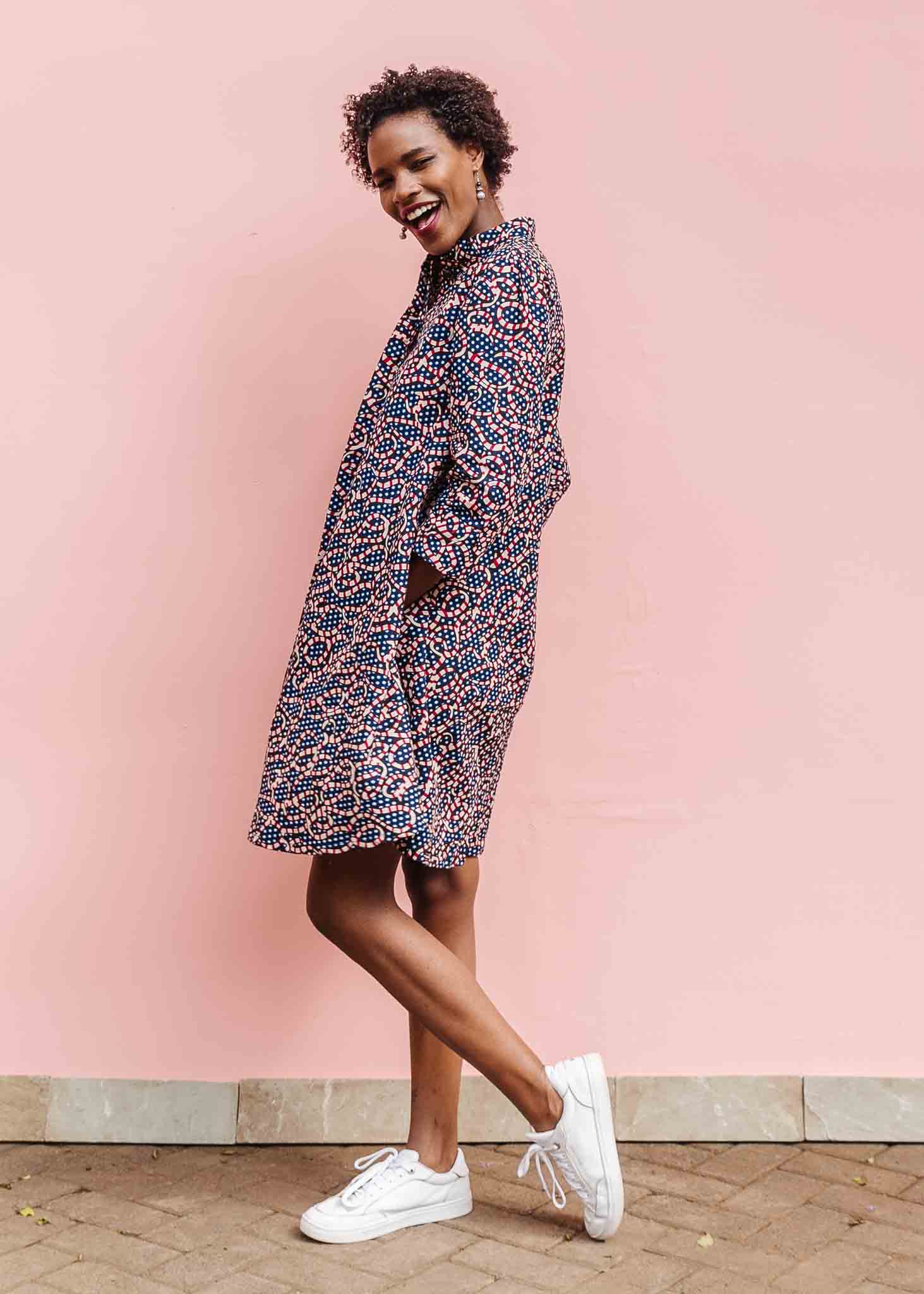 Model wearing blue and red ribbon print dress.