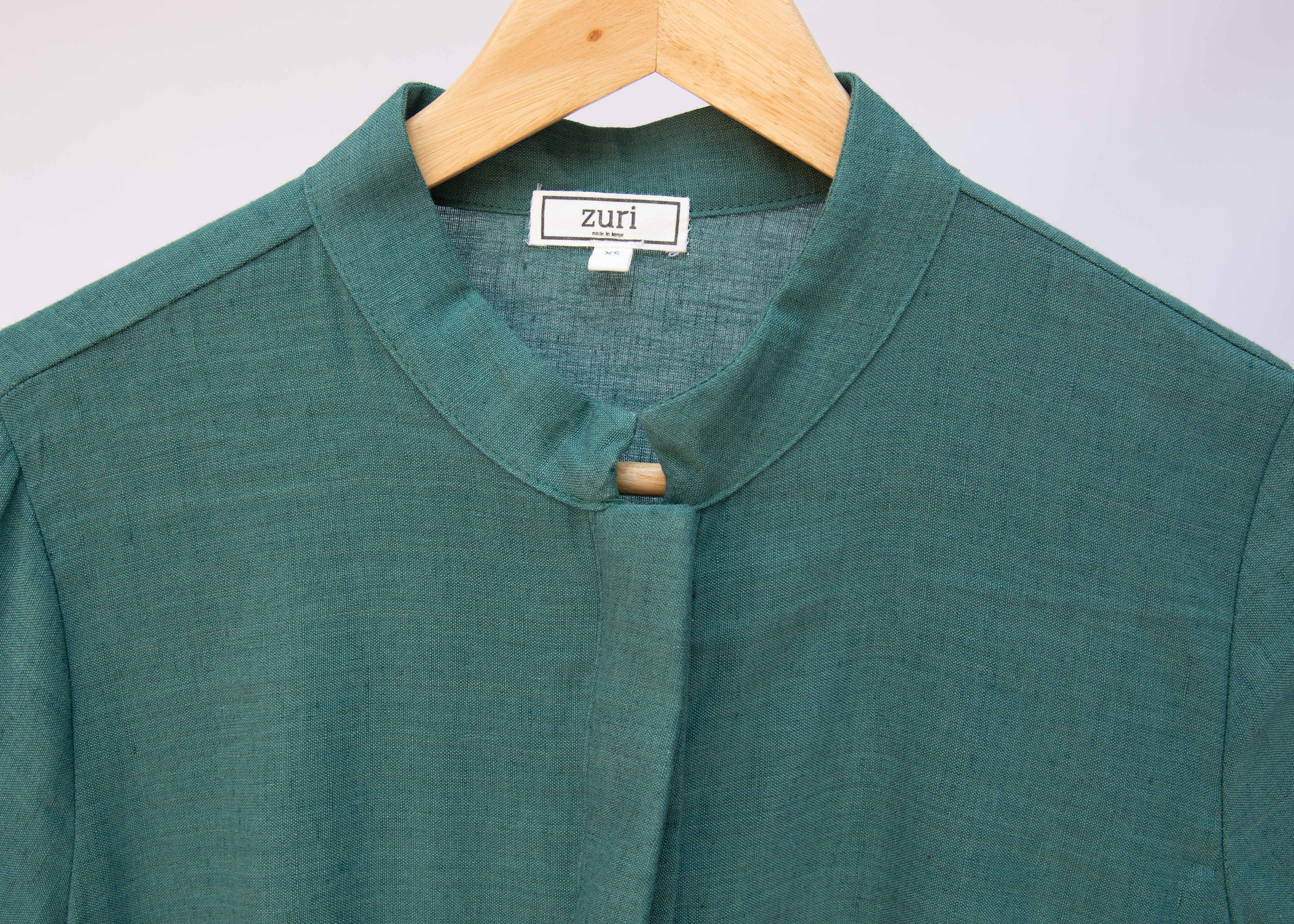 Close up display of lagoon green linen dress.