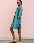 Model wearing lagoon green linen dress.