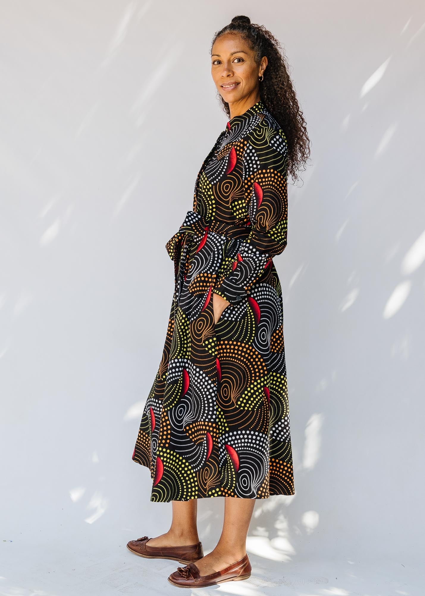model wearing abstract geometric midi-length belted dress