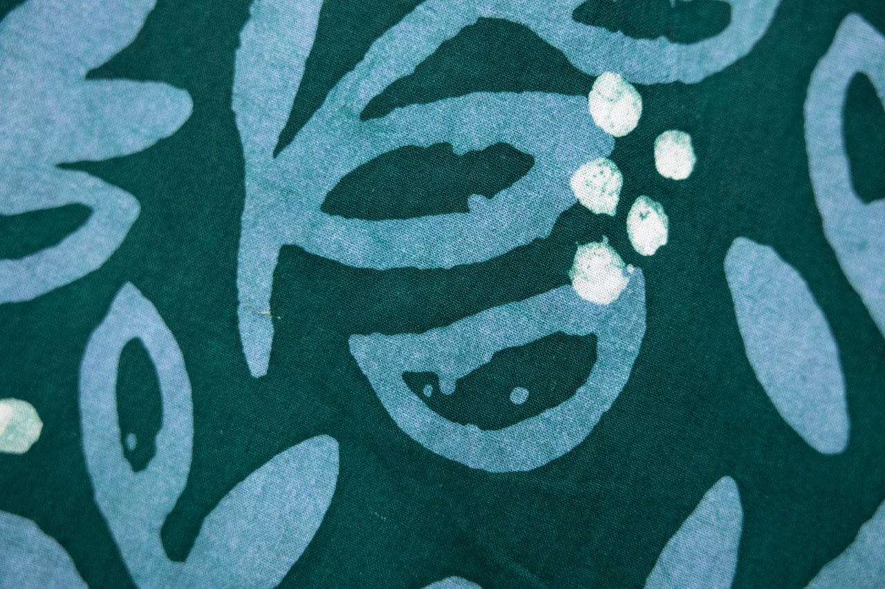 Close up display of green and blue floral batik dress, fabric.