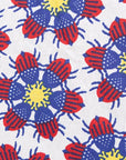 Close up display of white dress with yellow, red and blue bug print.