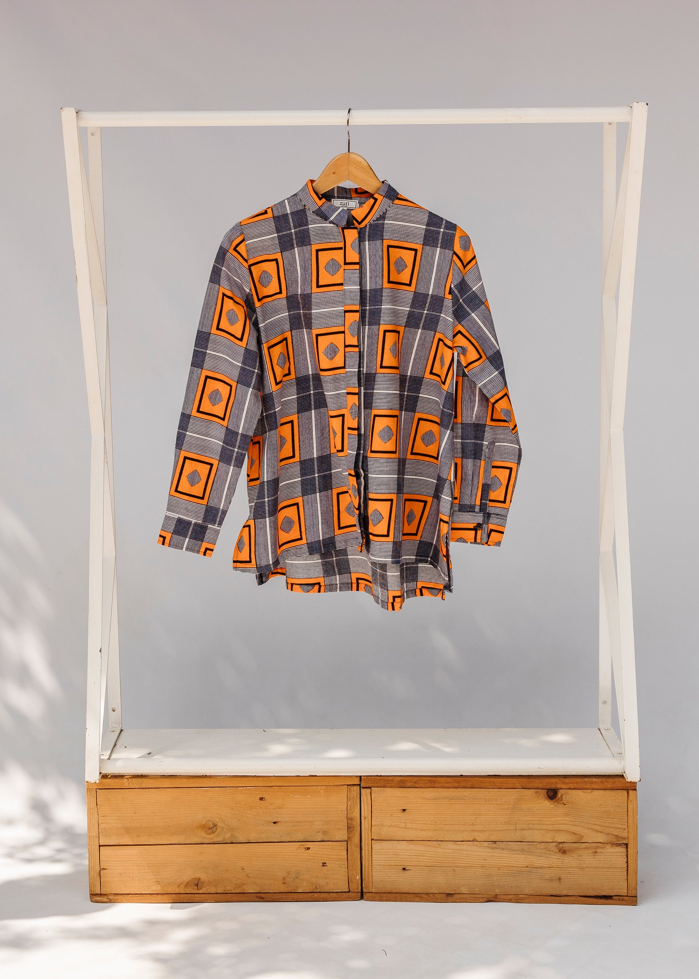Display of orange, navy and white geometric print shirt.