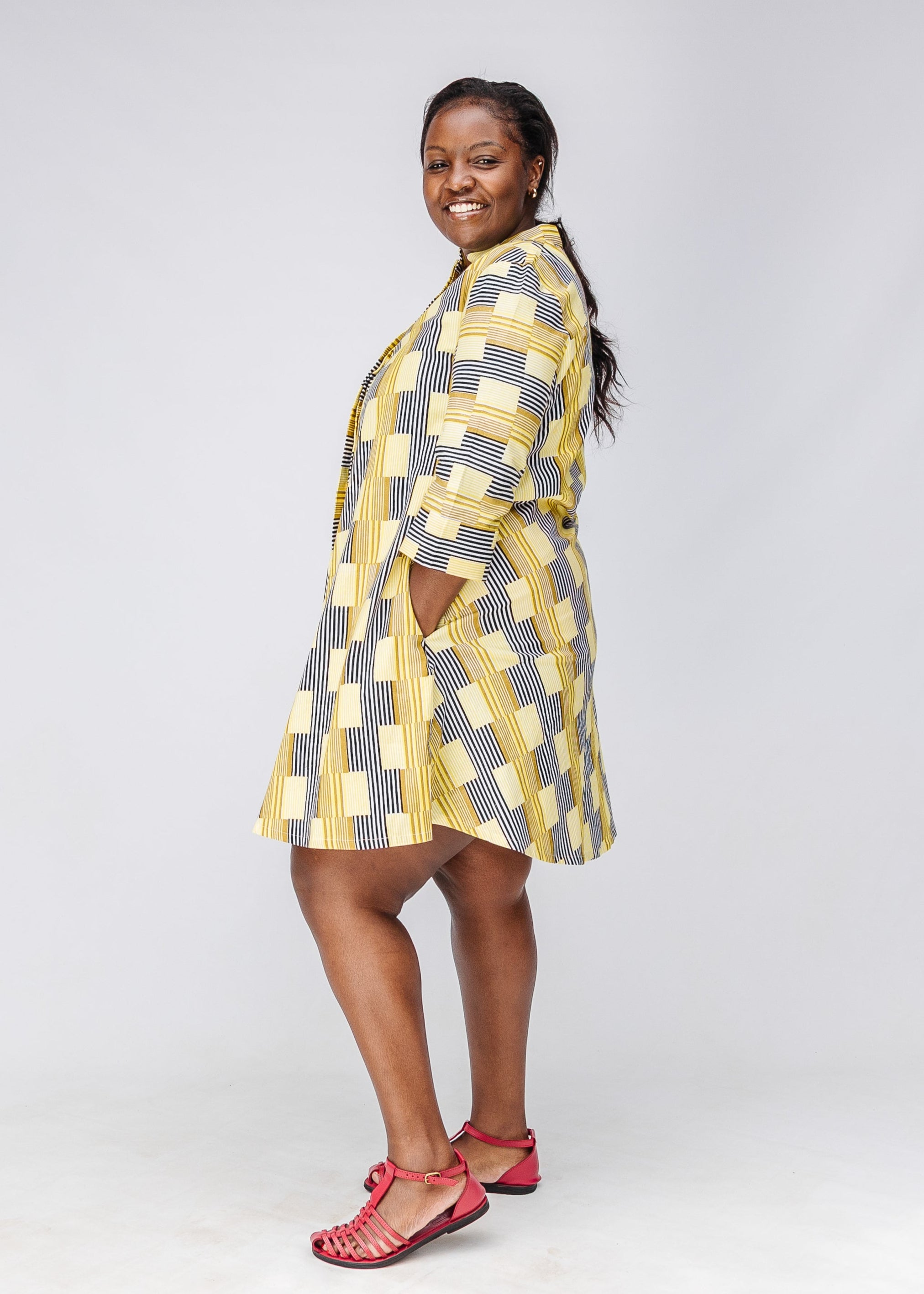 Model wearing yellow and black striped dress.