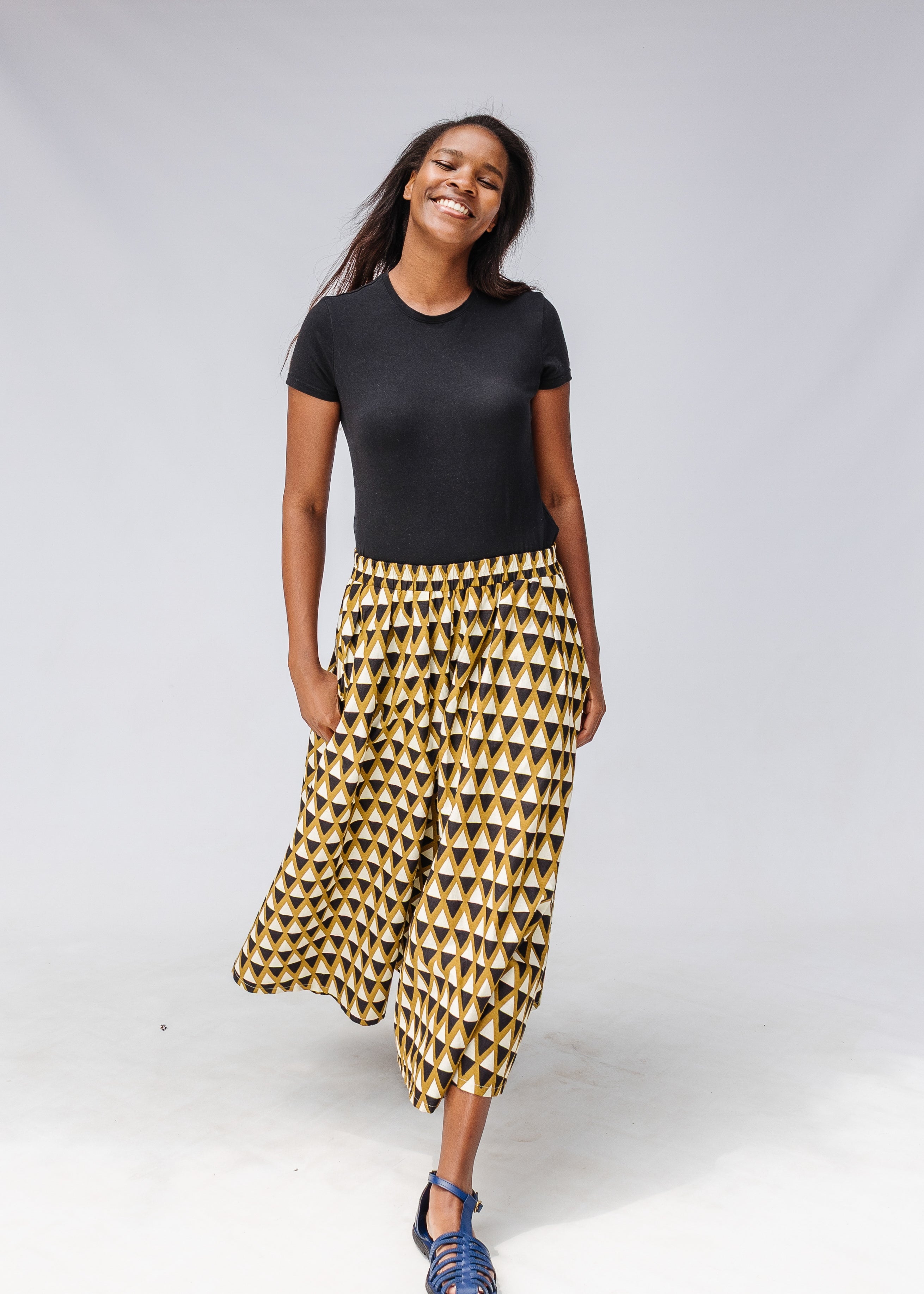 Model wearing black top and black and beige culotte.