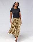 Model wearing black top and black and beige culotte.