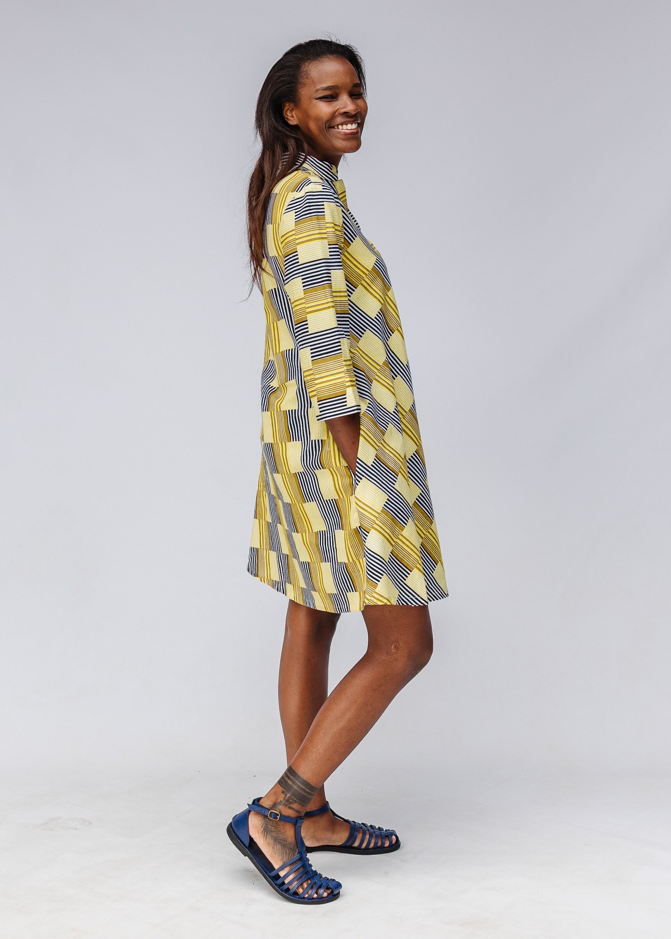 Model wearing yellow and black striped dress.