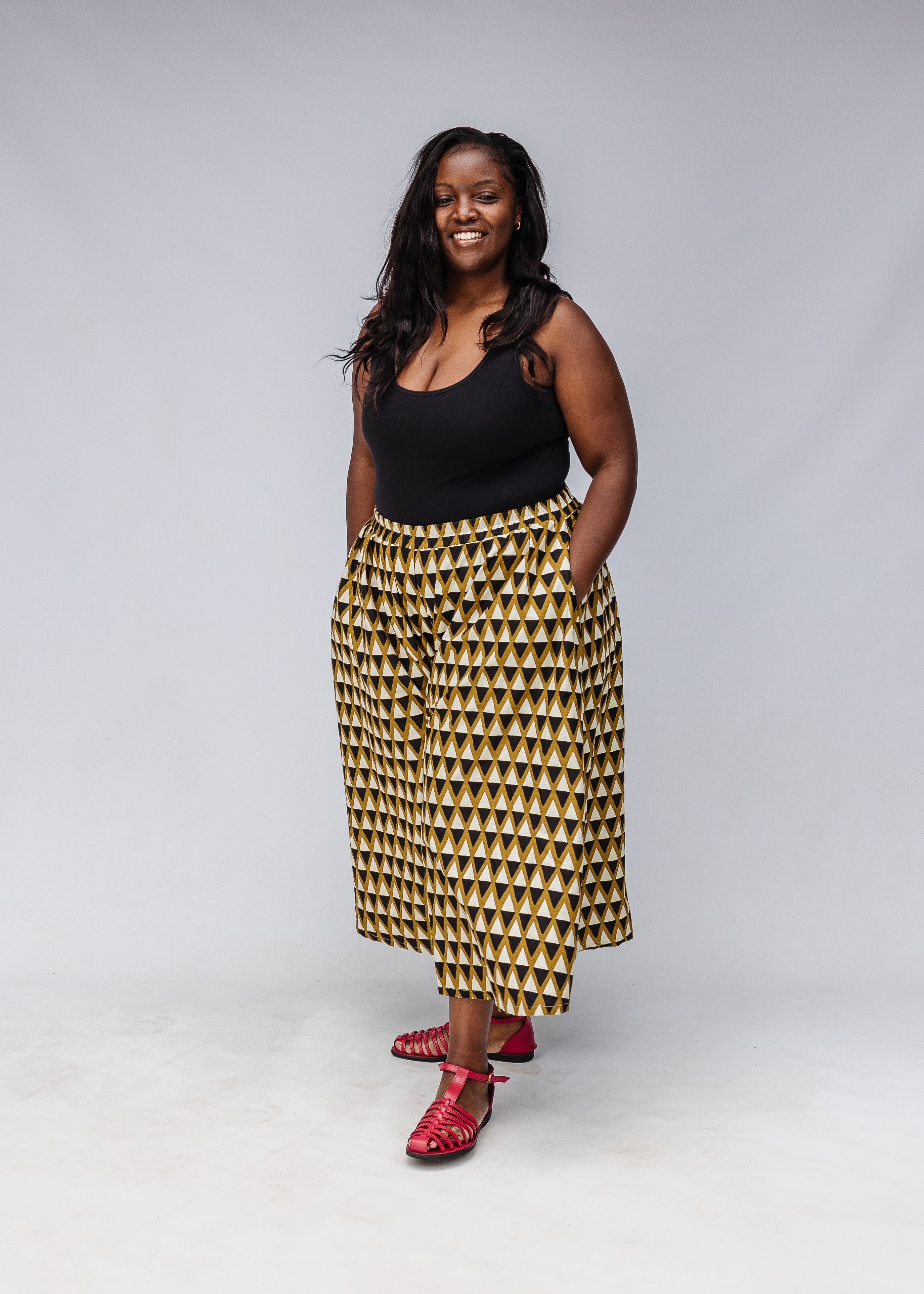 Model wearing black top with black and beige culotte.