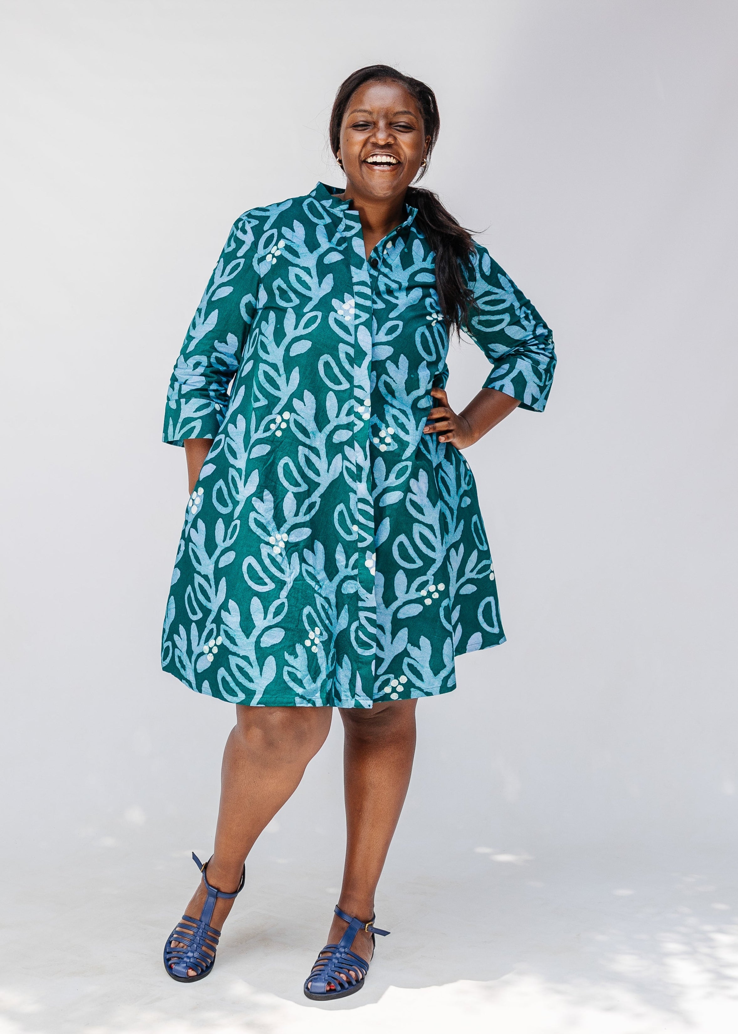 Model wearing green and blue floral batik dress. 