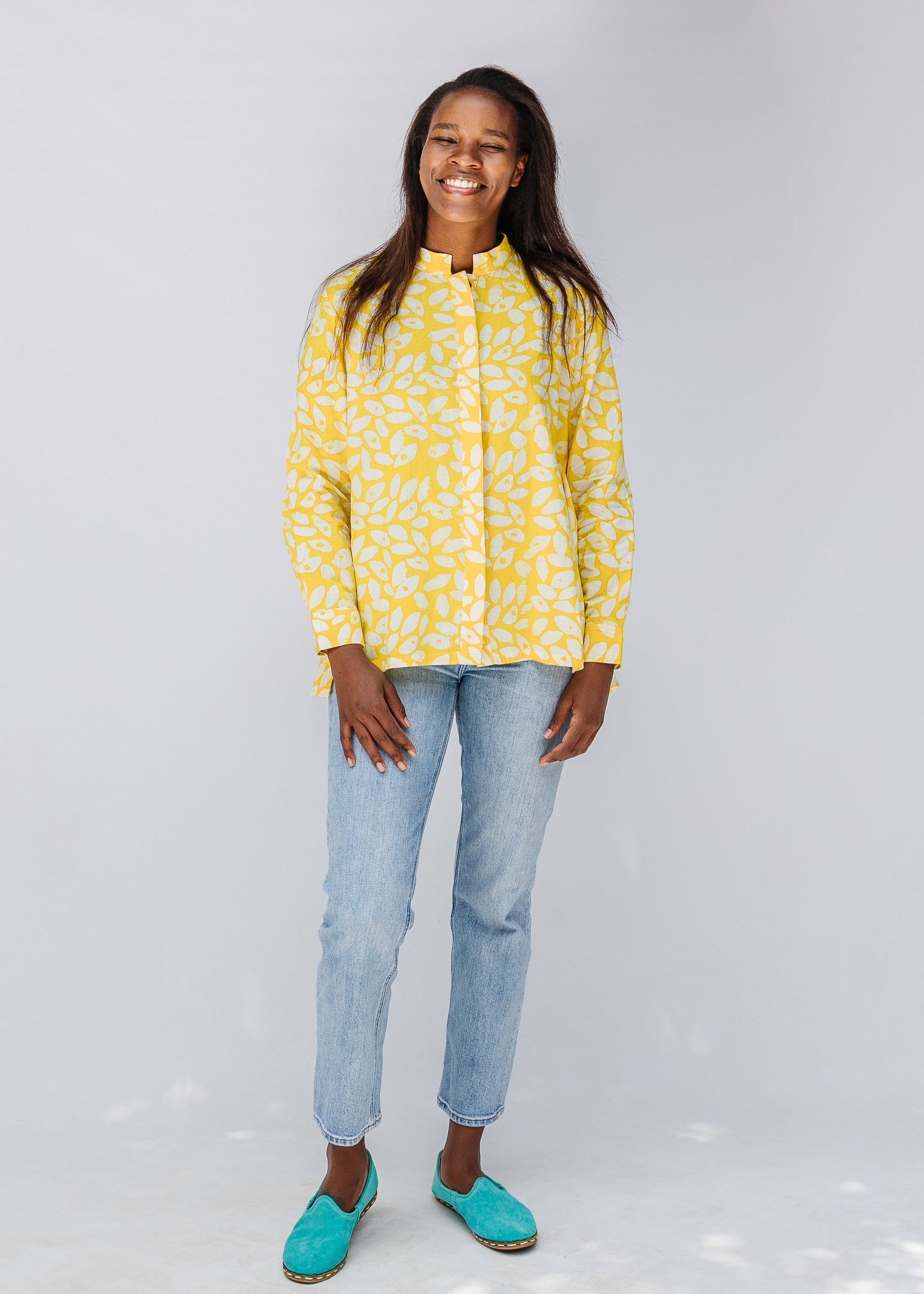 Model wearing yellow long sleeve shirt with white leaf print.