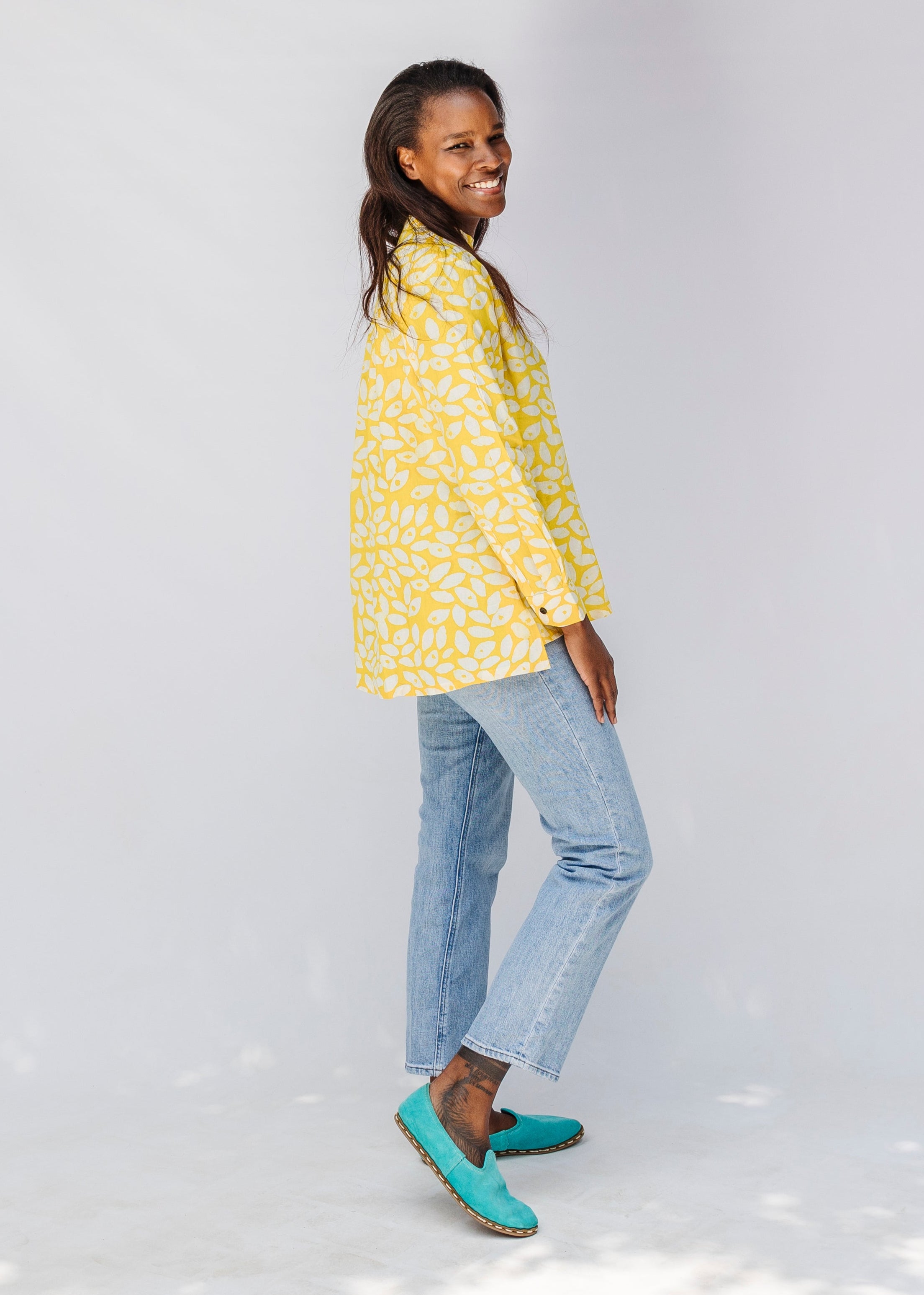 Model wearing yellow long sleeve shirt with white leaf print.