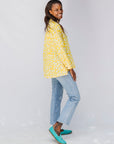 Model wearing yellow long sleeve shirt with white leaf print.