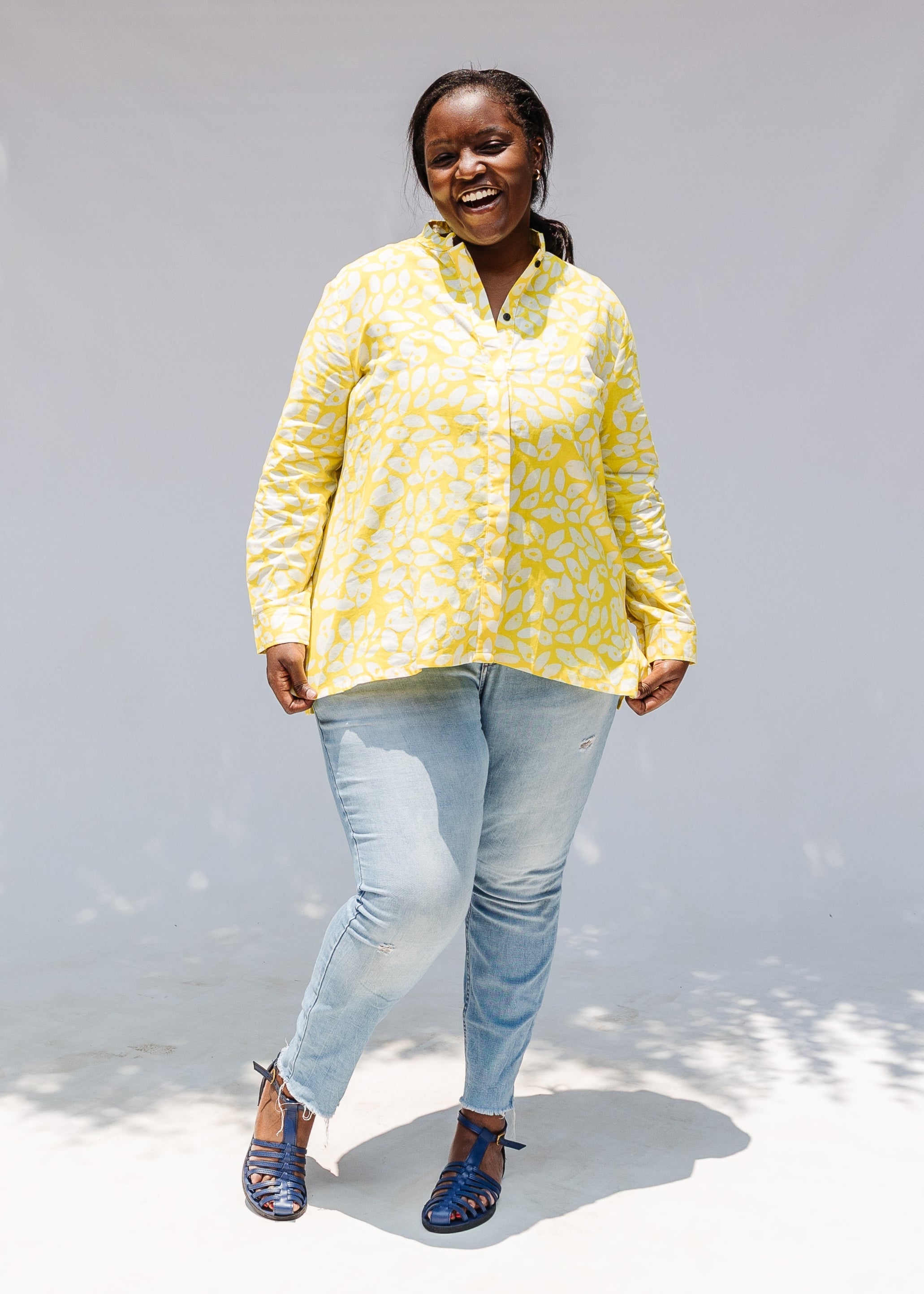 Model wearing yellow long sleeve shirt with white leaf print.