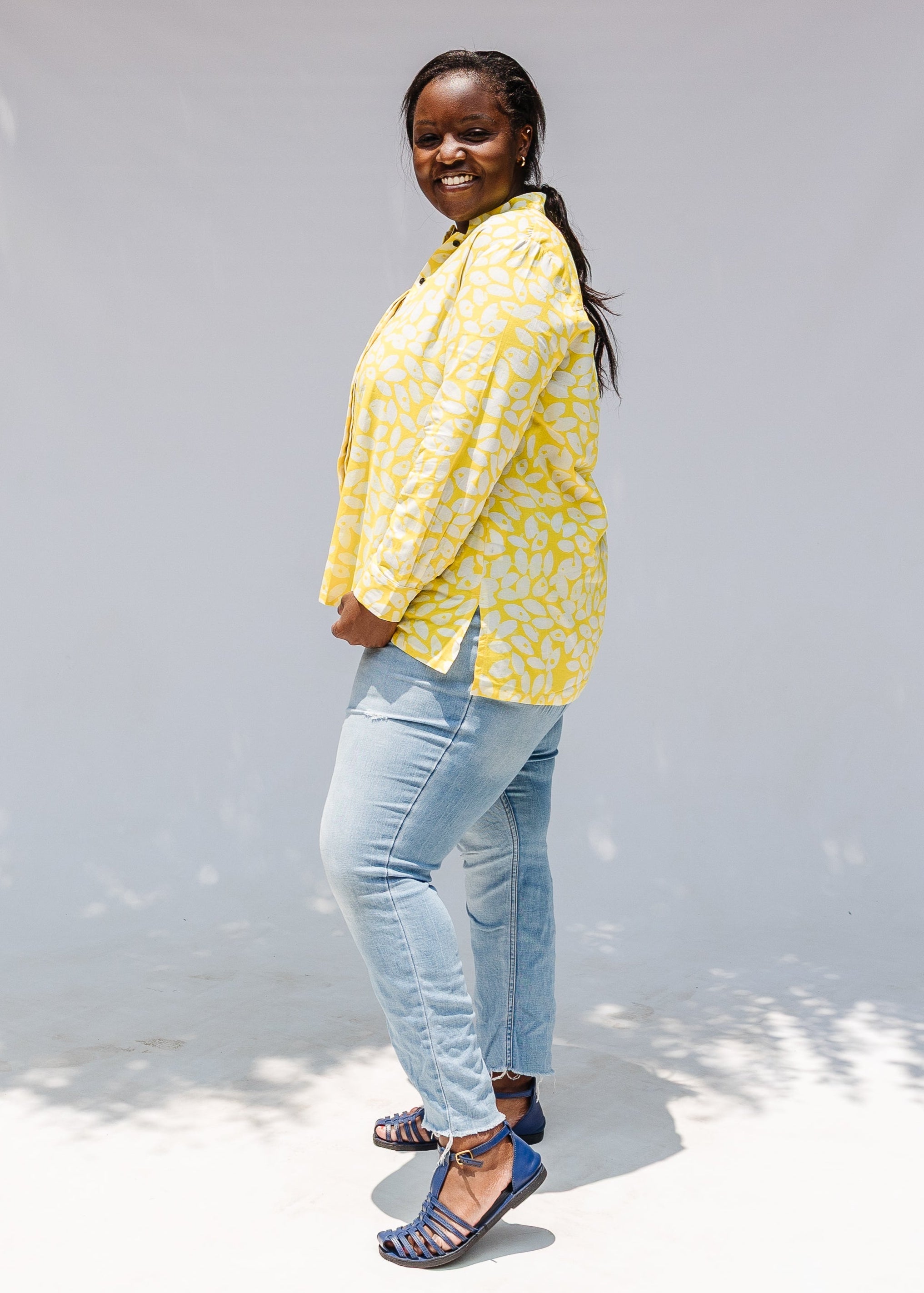 Model wearing yellow long sleeve shirt with white leaf print.