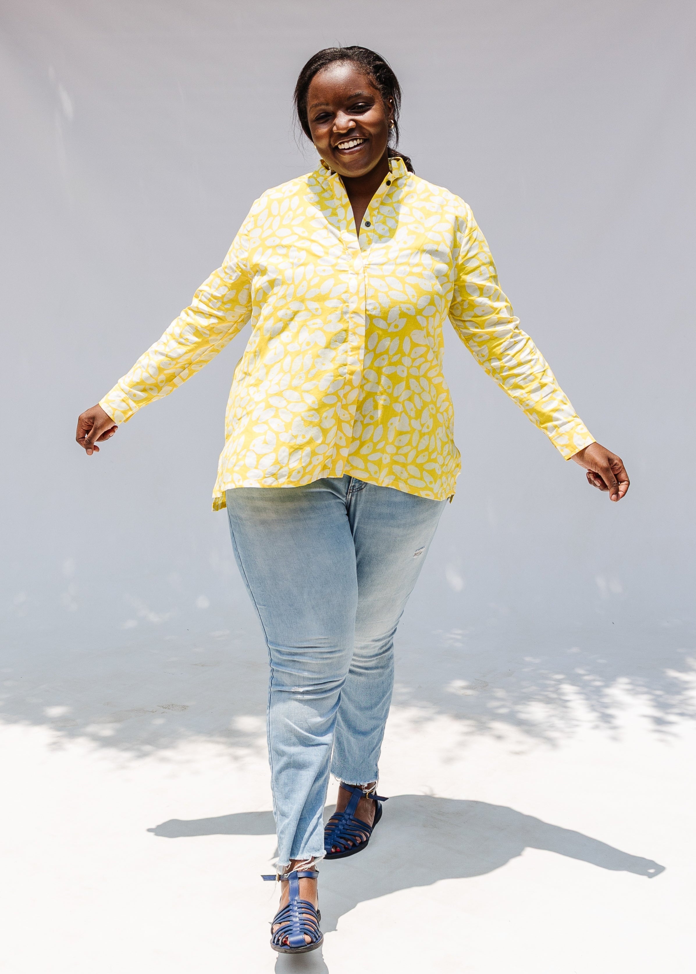 Model wearing yellow long sleeve shirt with white leaf print.