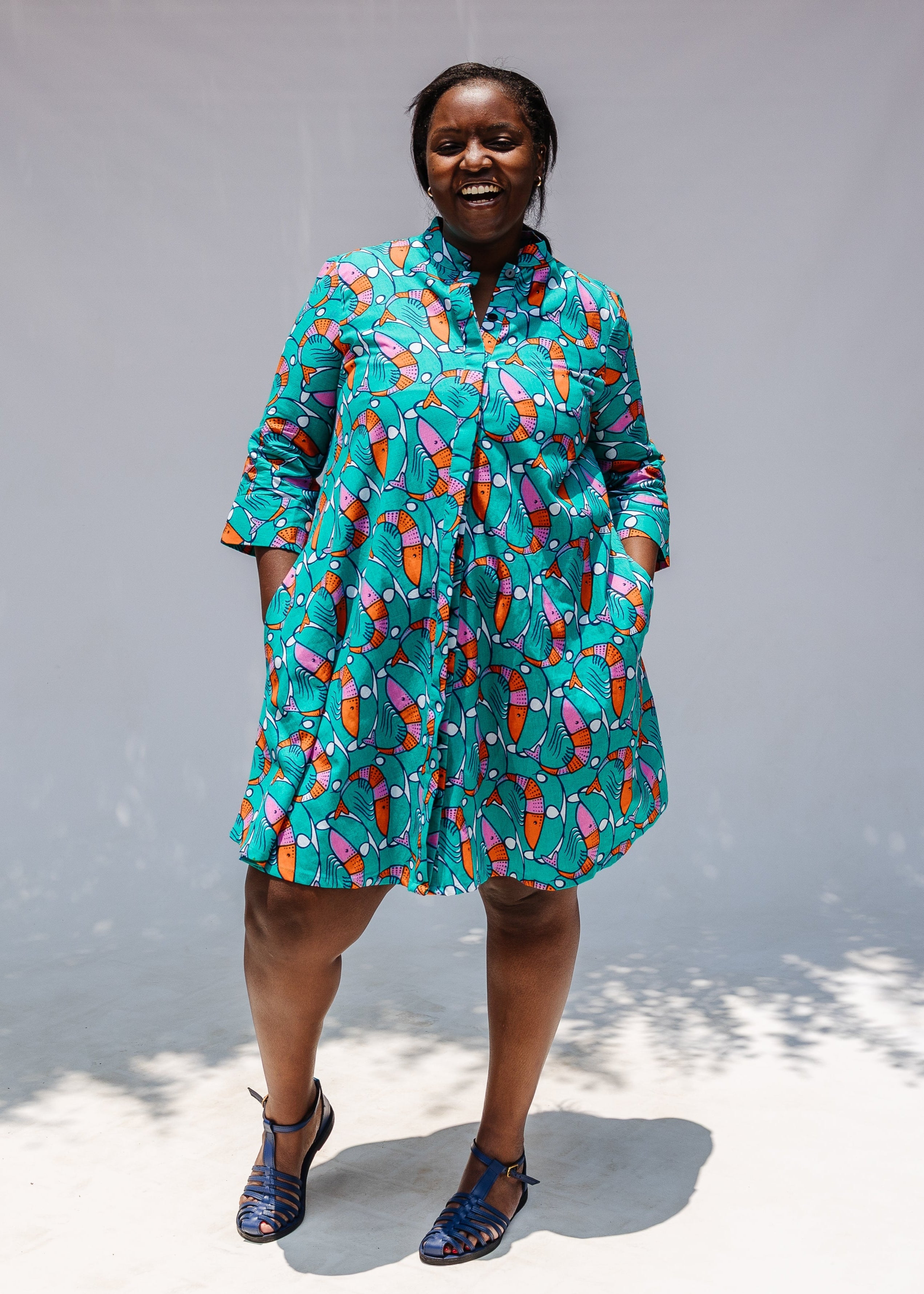 Model wearing teal dress with pink and orange shrimp print.