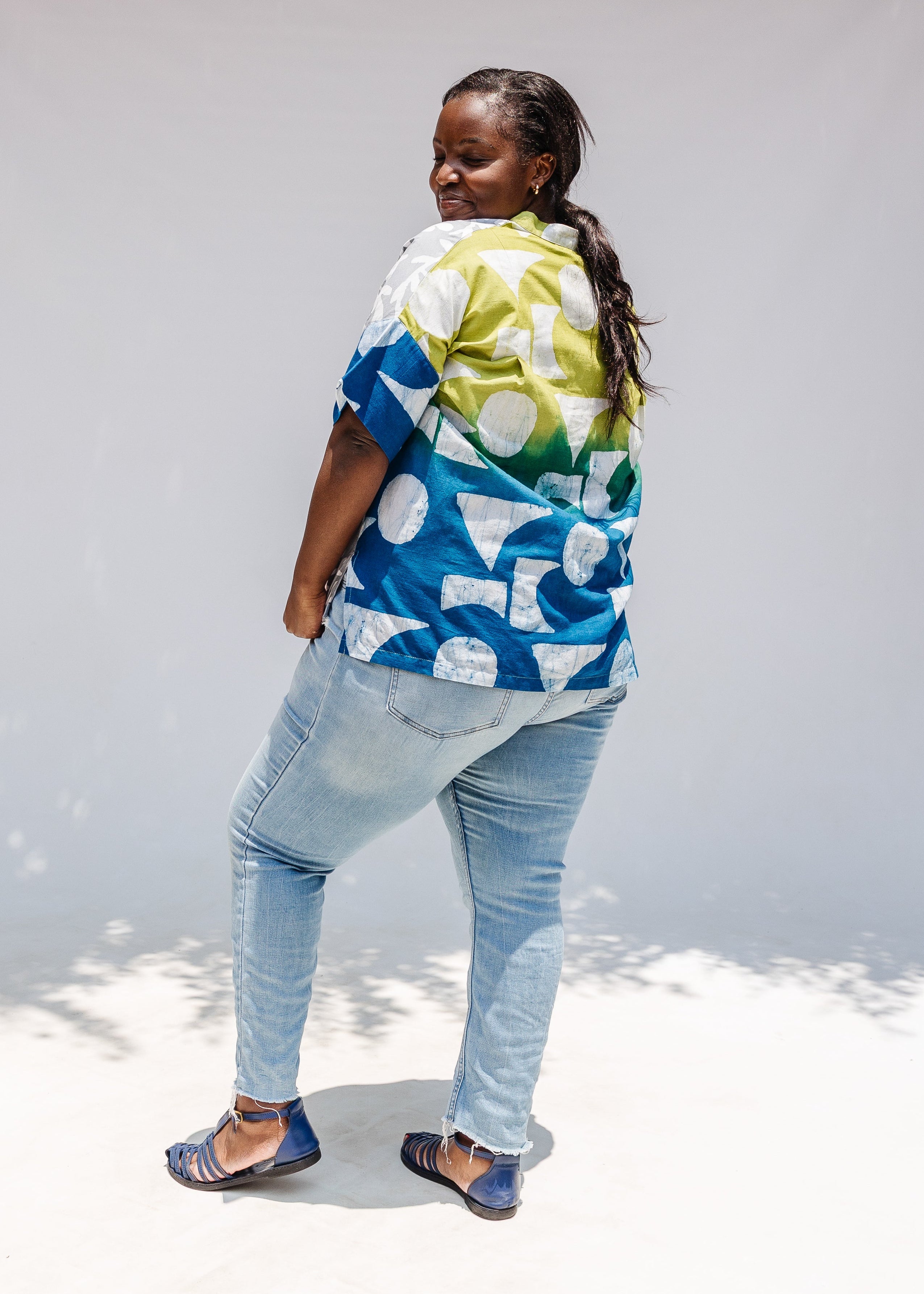 Model wearing mutlicolored batik shortsleeved shirt.