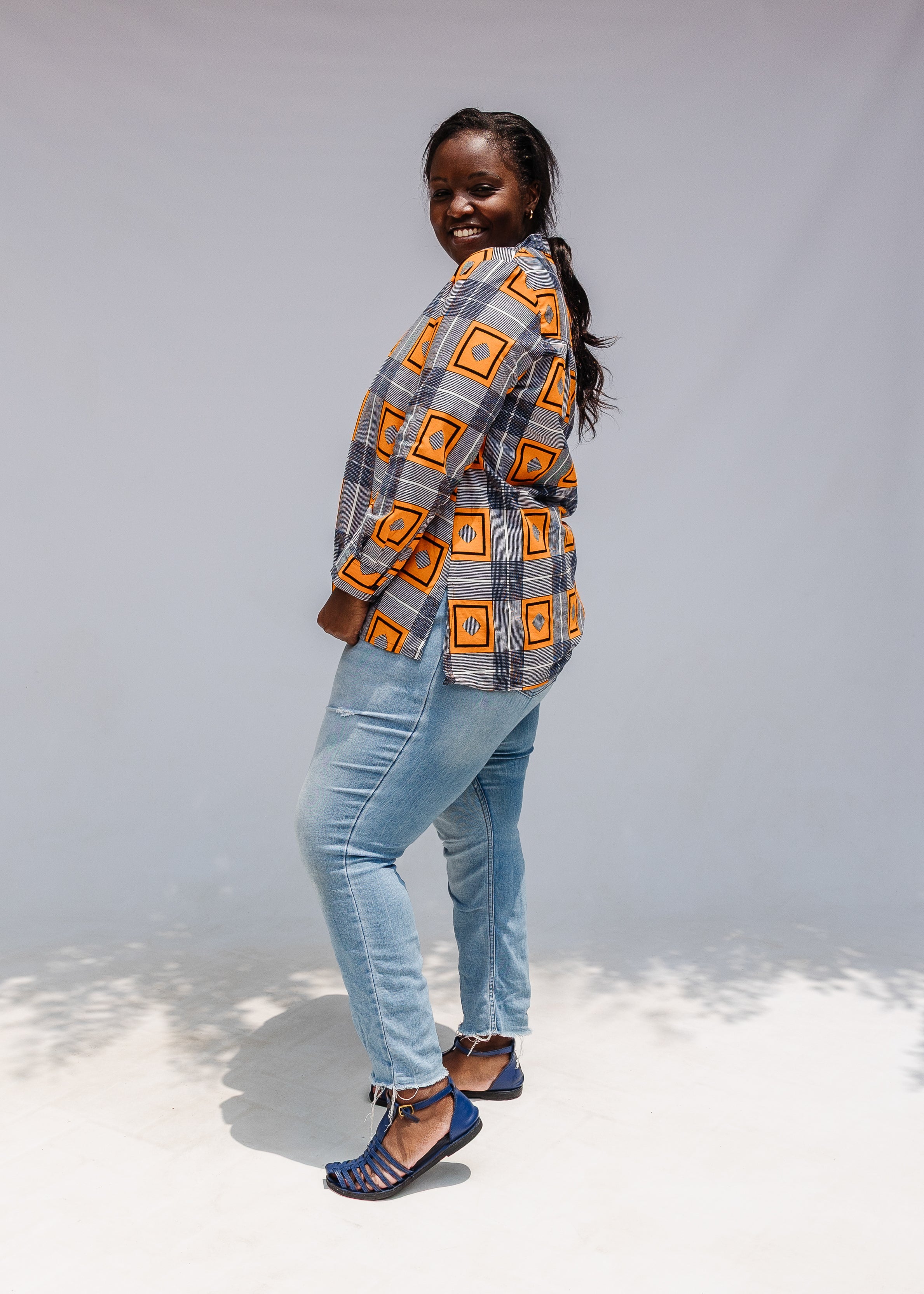 Model wearing orange, navy and white geometric print shirt.