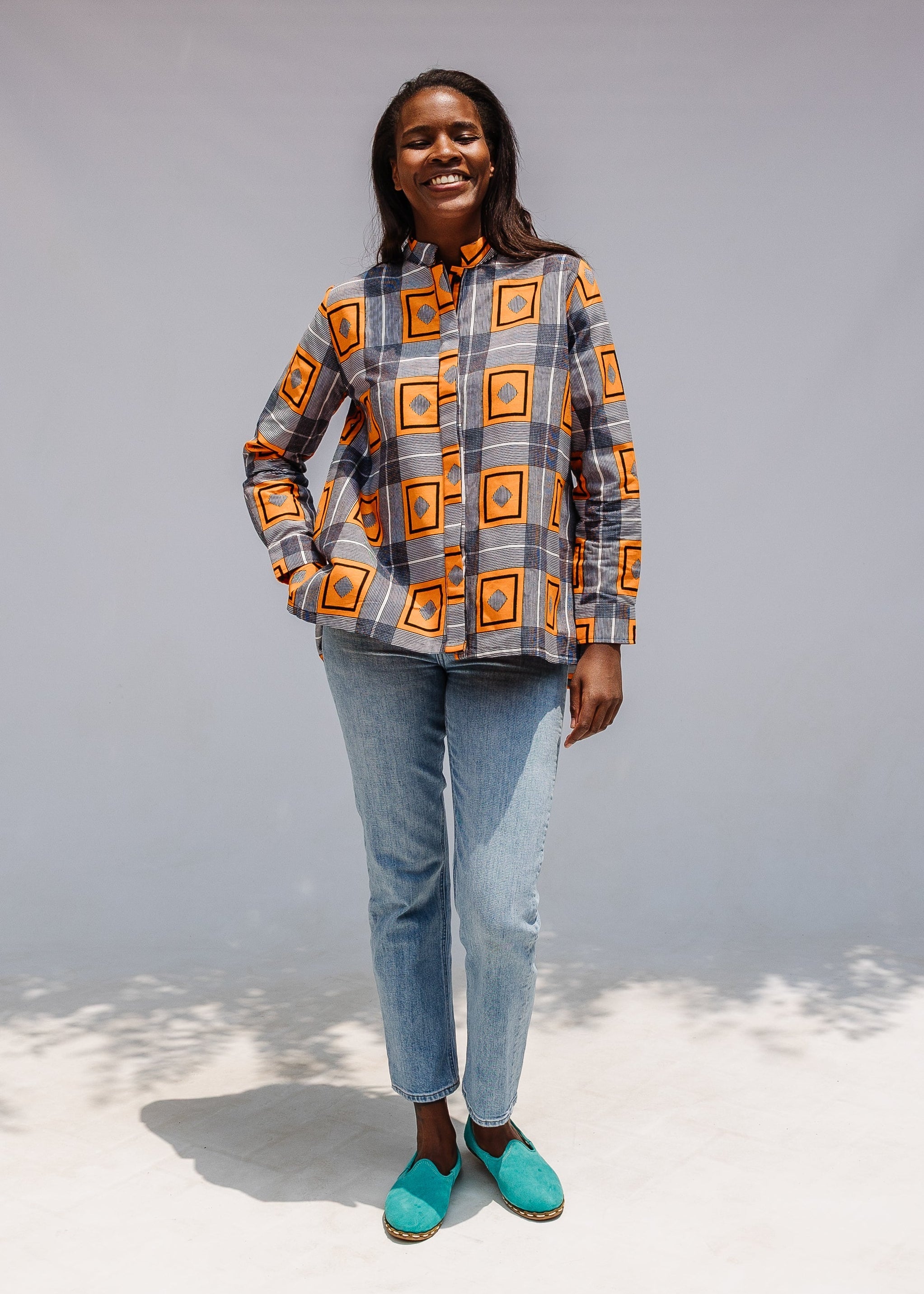 Model wearing orange, navy and white geometric print shirt.