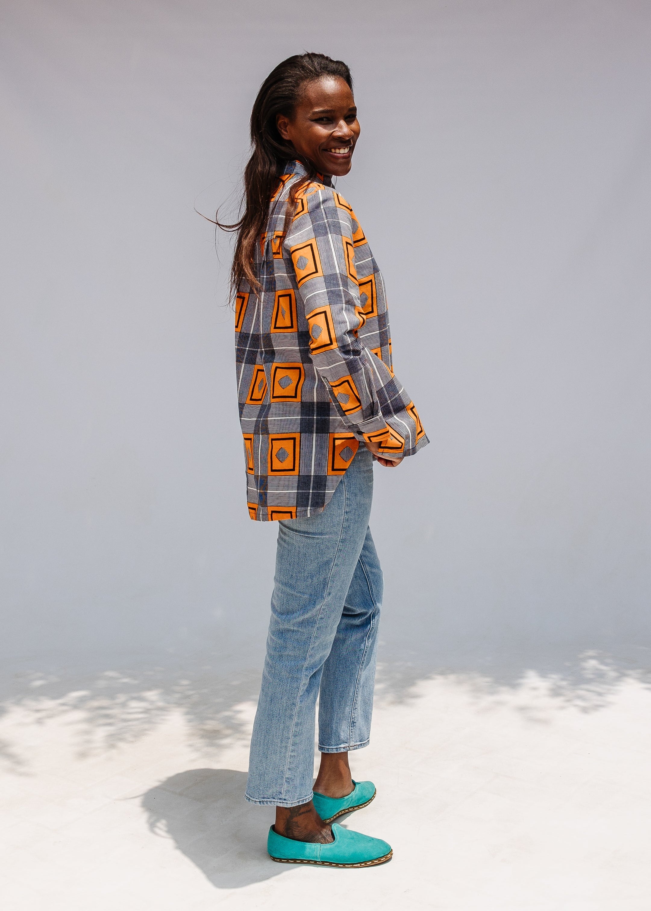 Model wearing orange, navy and white geometric print shirt.