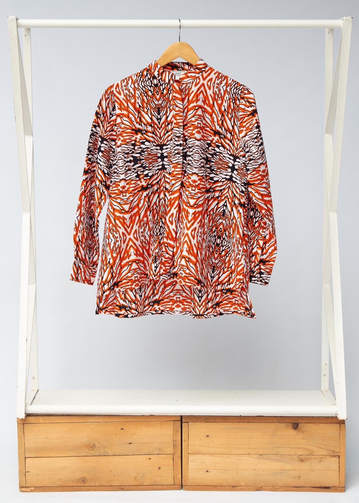 Display of orange, black and white abstract print long sleeved shirt