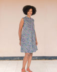 Model wearing purple sleeveless dress with wheat print.
