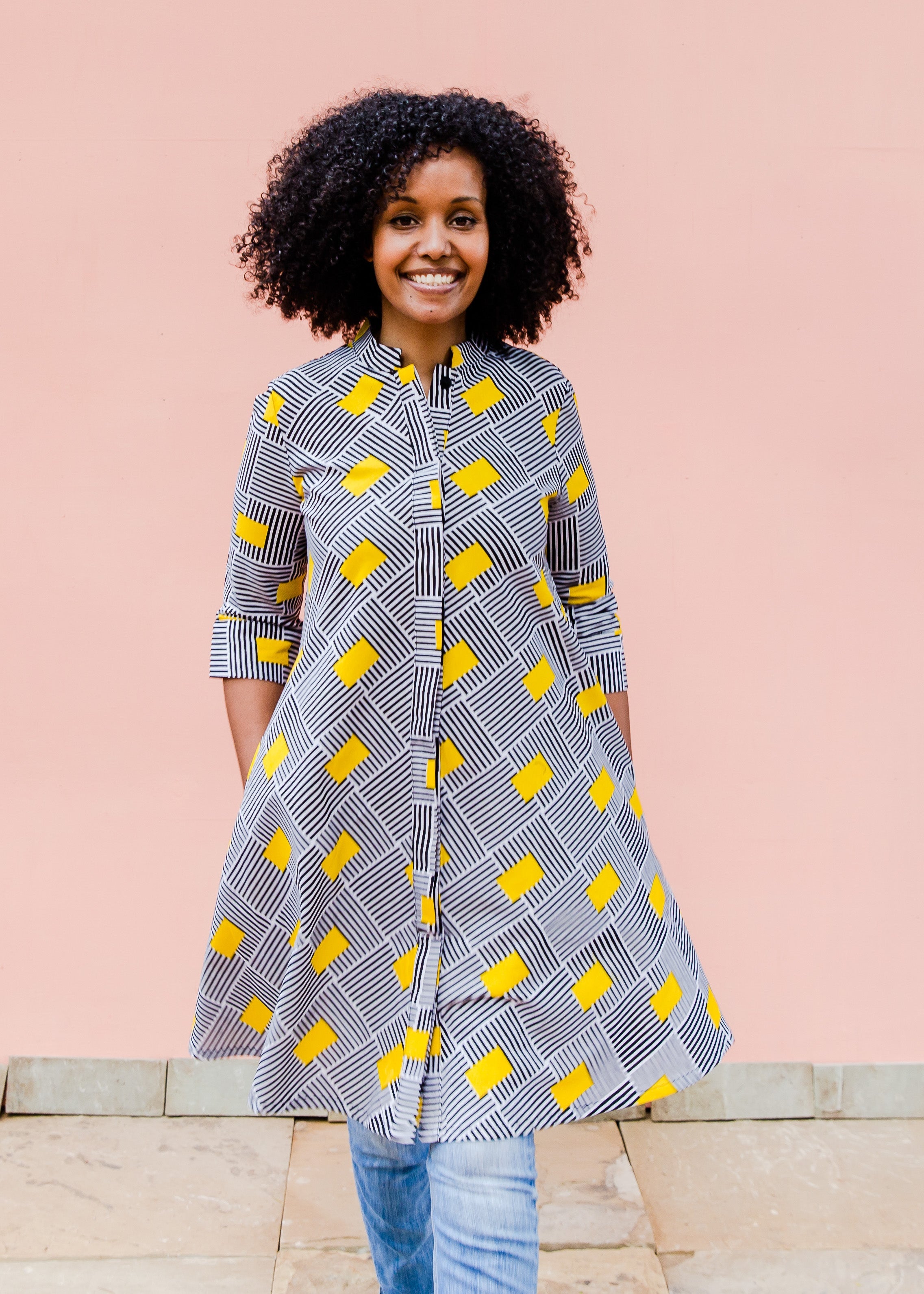 Model wearing black and white striped dress with yellow block print.