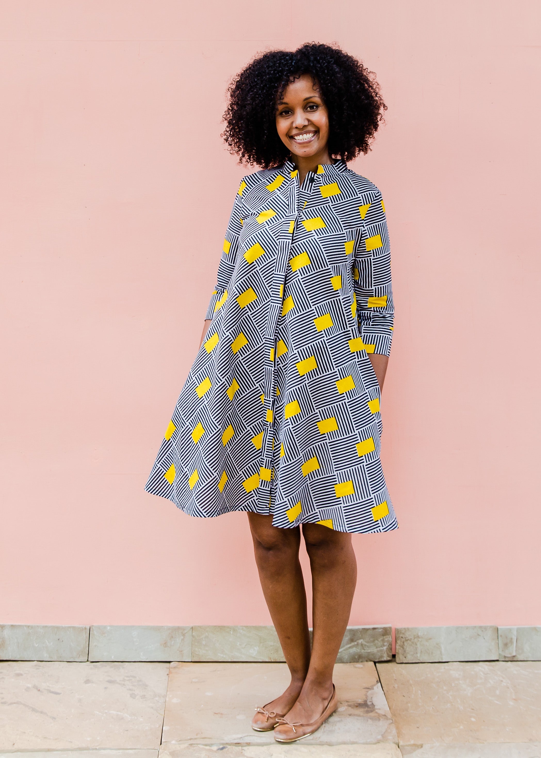 Model wearing black and white striped dress with yellow block print.
