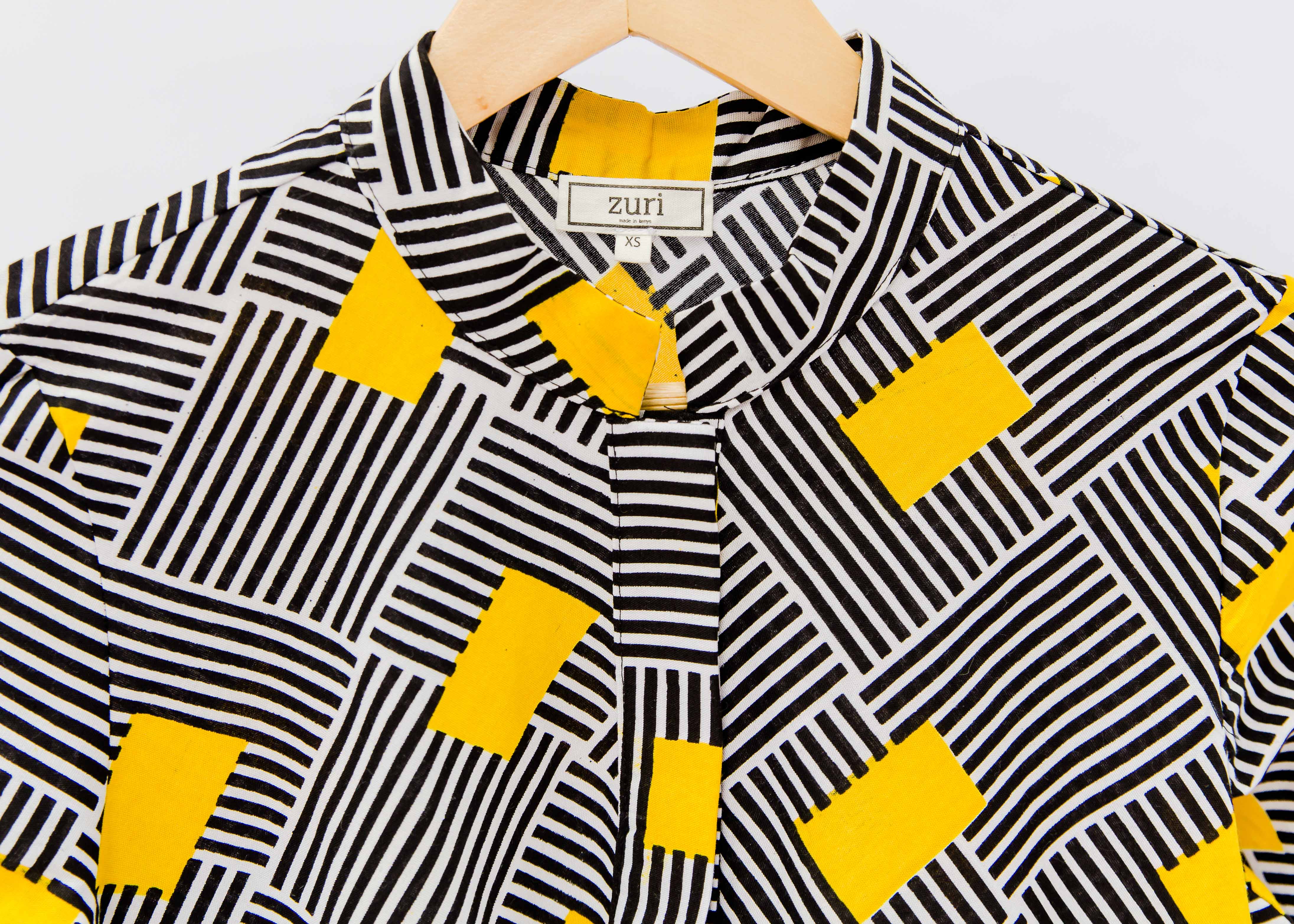 Display of black and white striped dress with yellow block print.