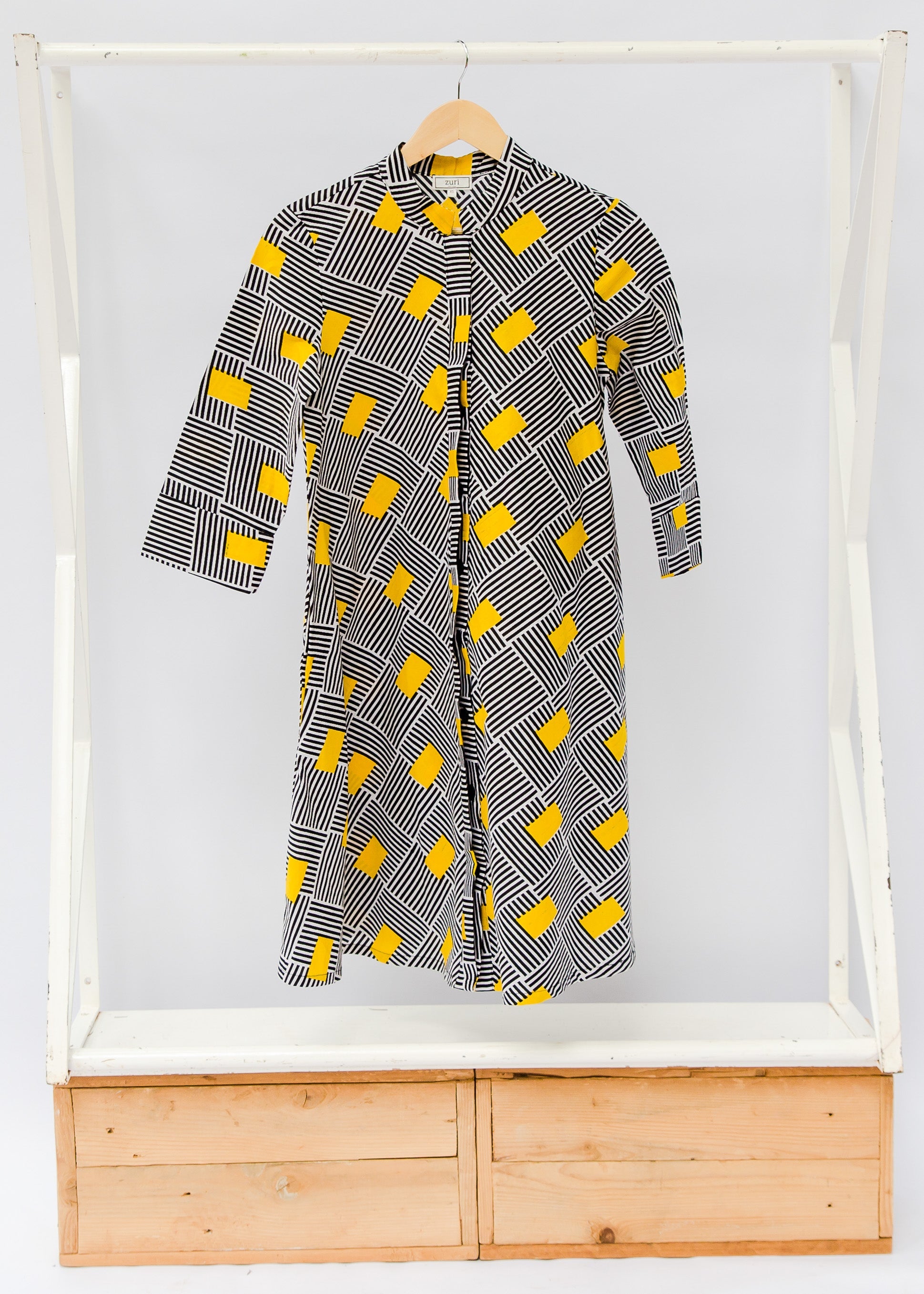Display of black and white striped dress with yellow block print.