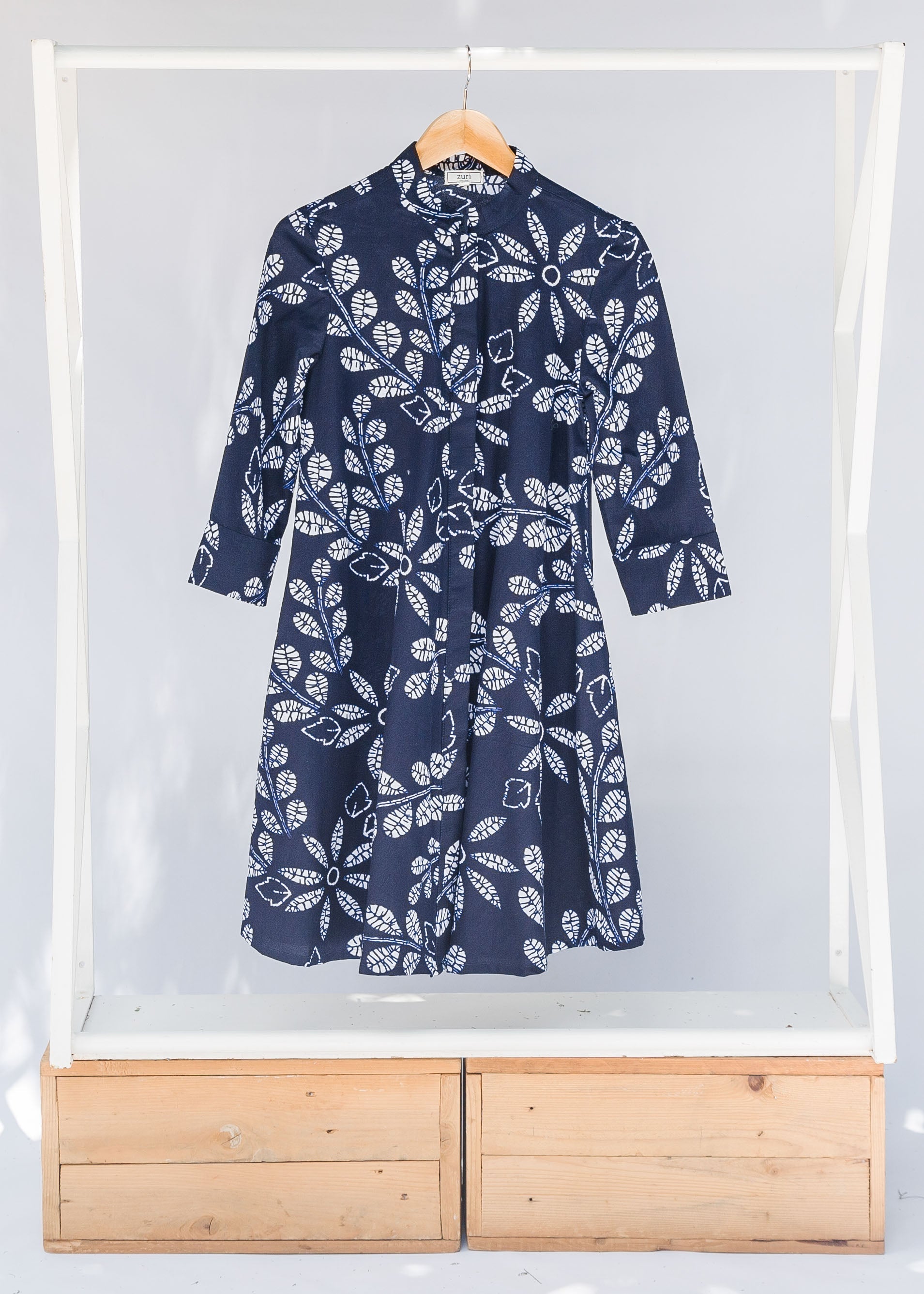 Display of navy dress with white floral print.