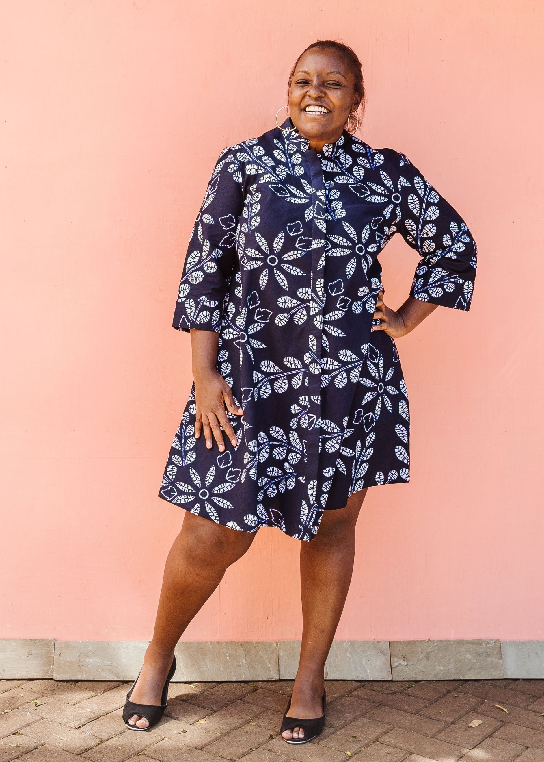 Model wearing navy dress with white floral print.