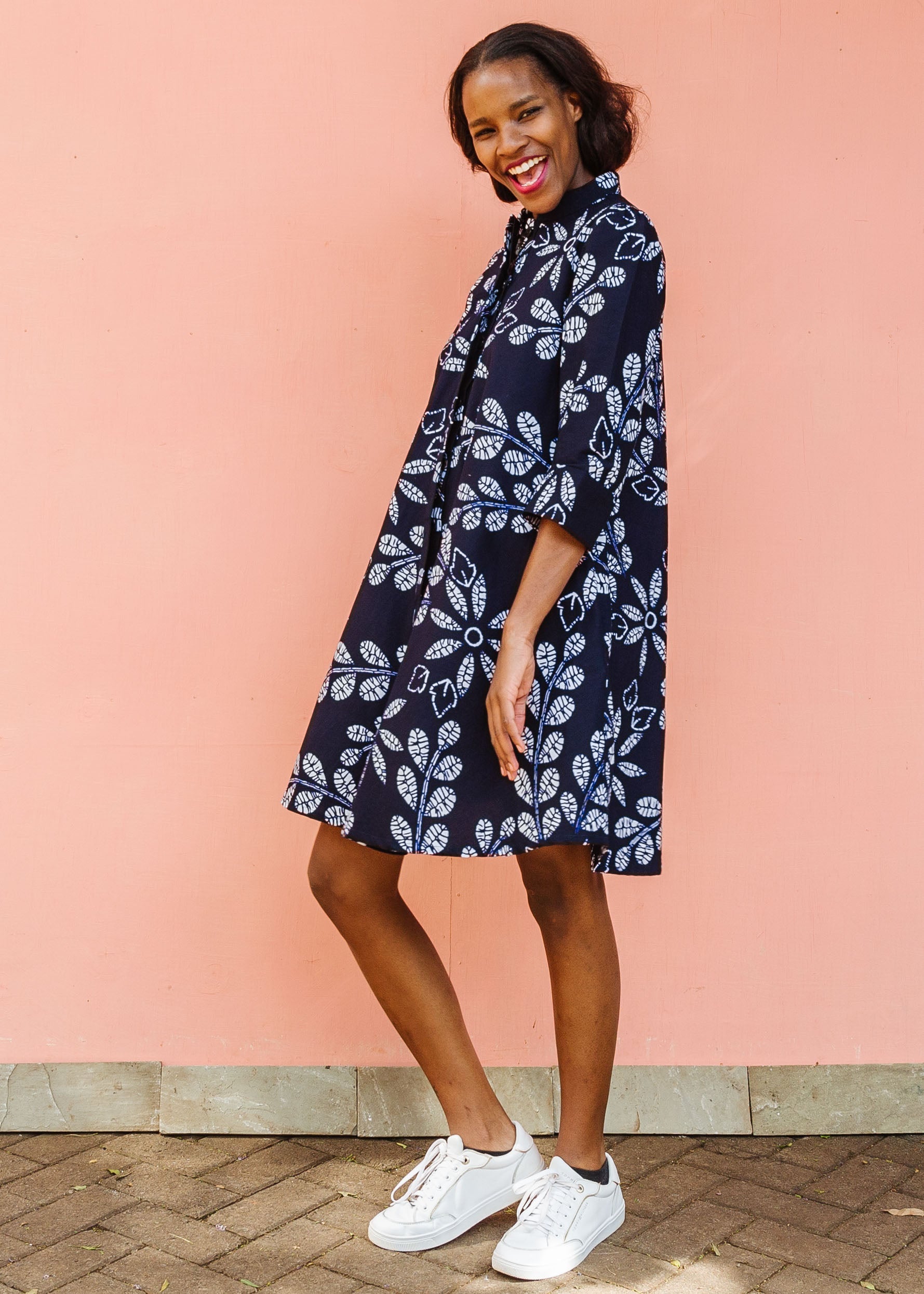 Model wearing navy dress with white floral print.