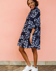 Model wearing navy dress with white floral print.
