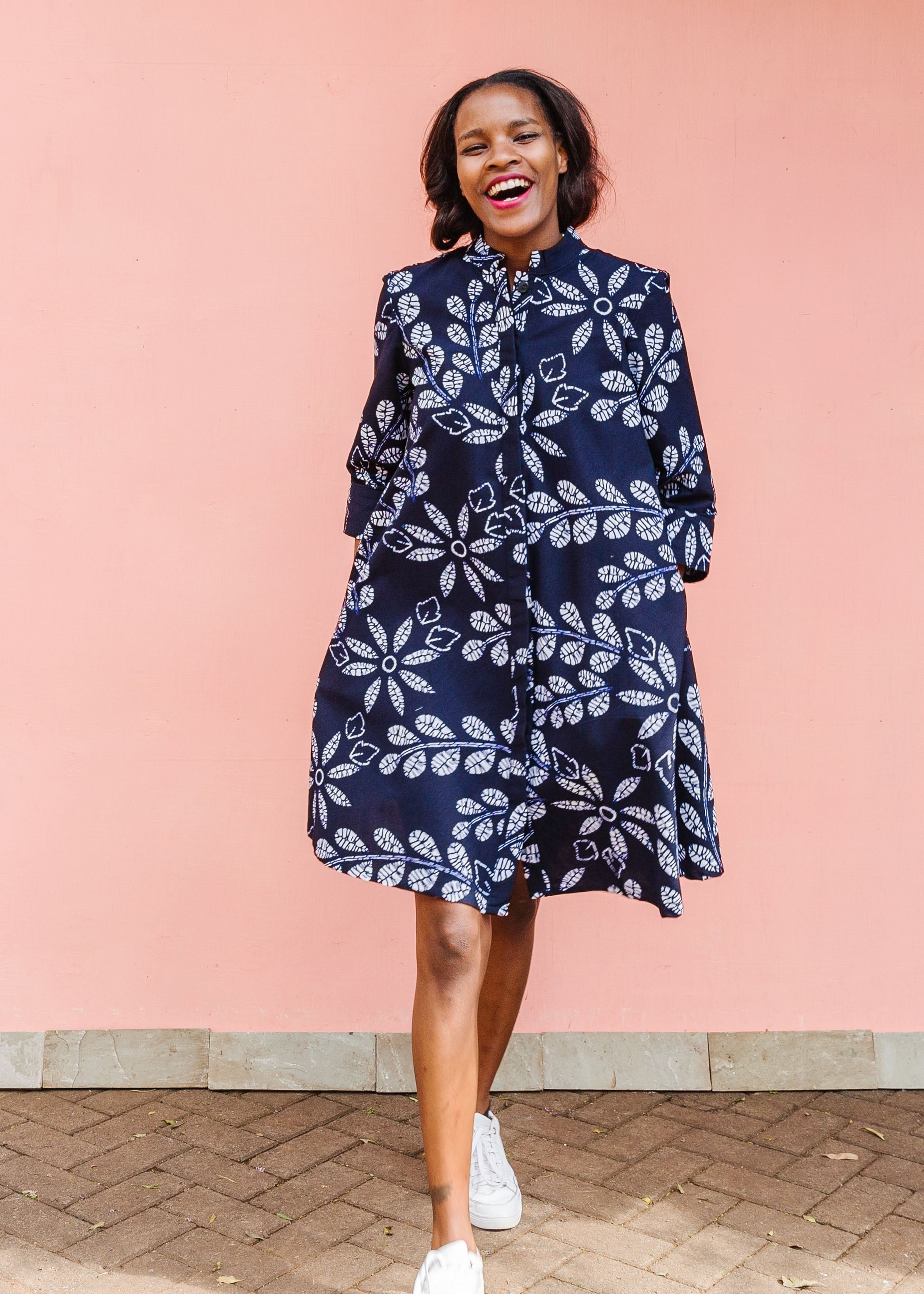 Model wearing navy dress with white floral print.