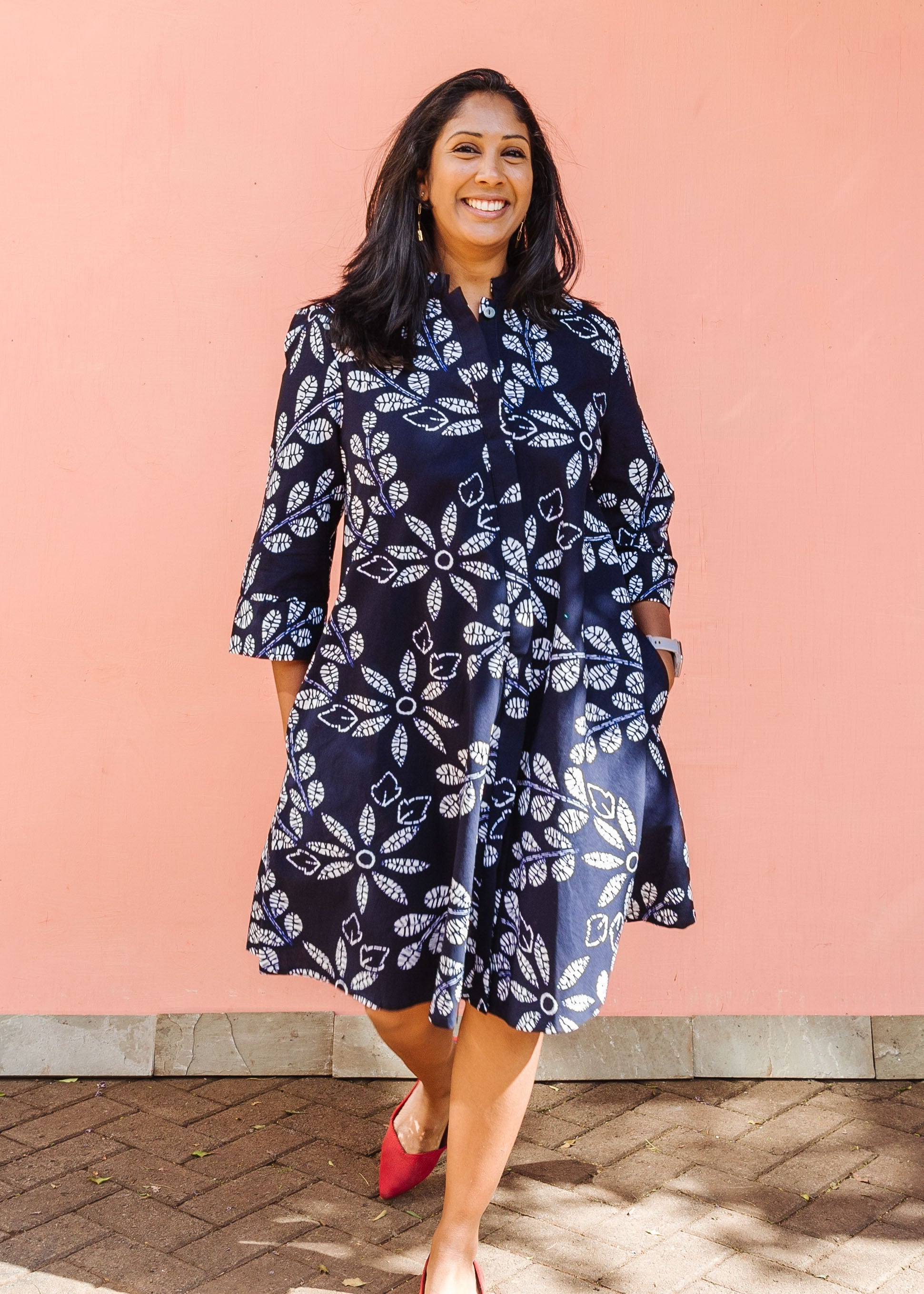 Model wearing navy dress with white floral print.