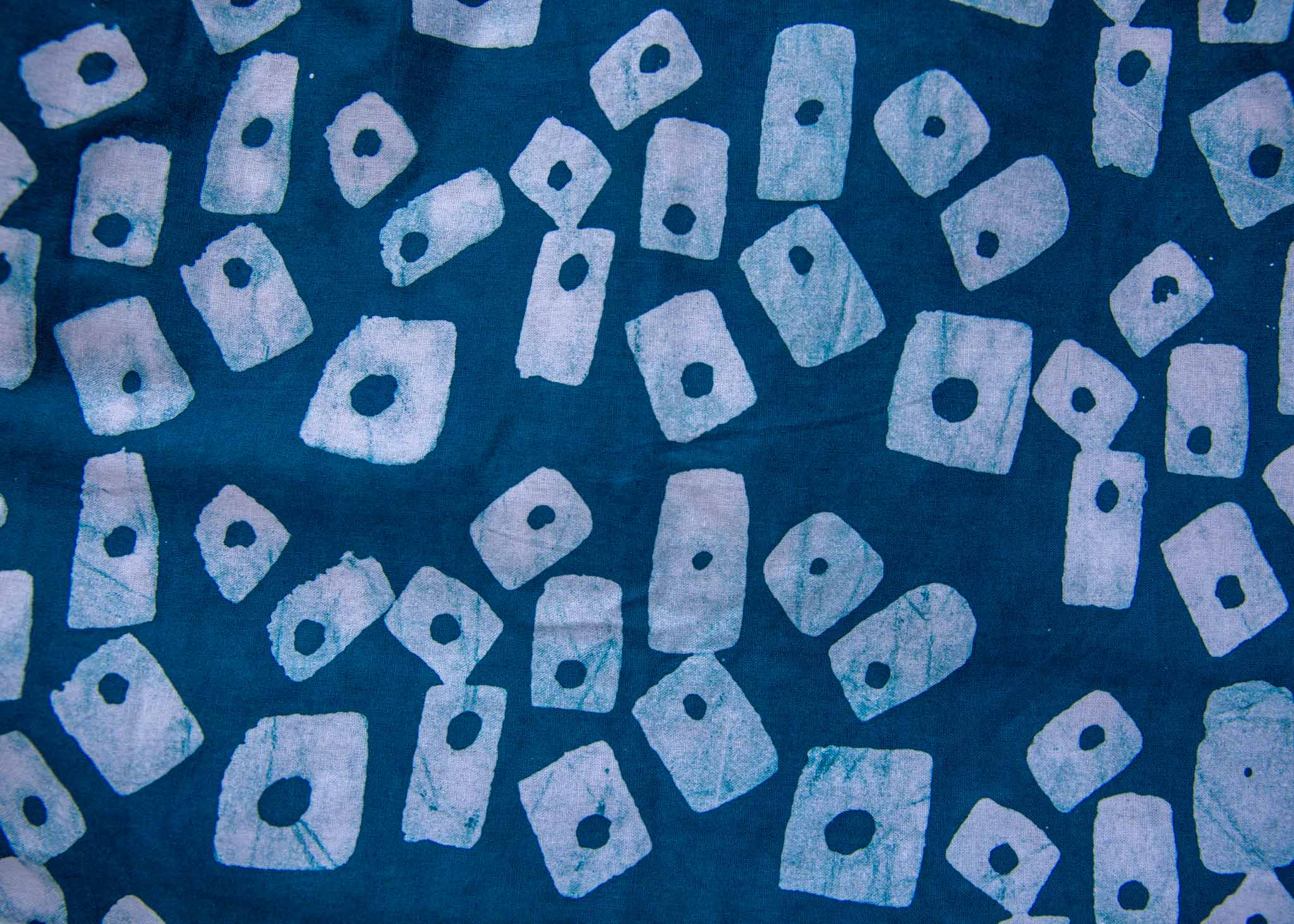 Close up display of blue, white domino print shirt, fabric.