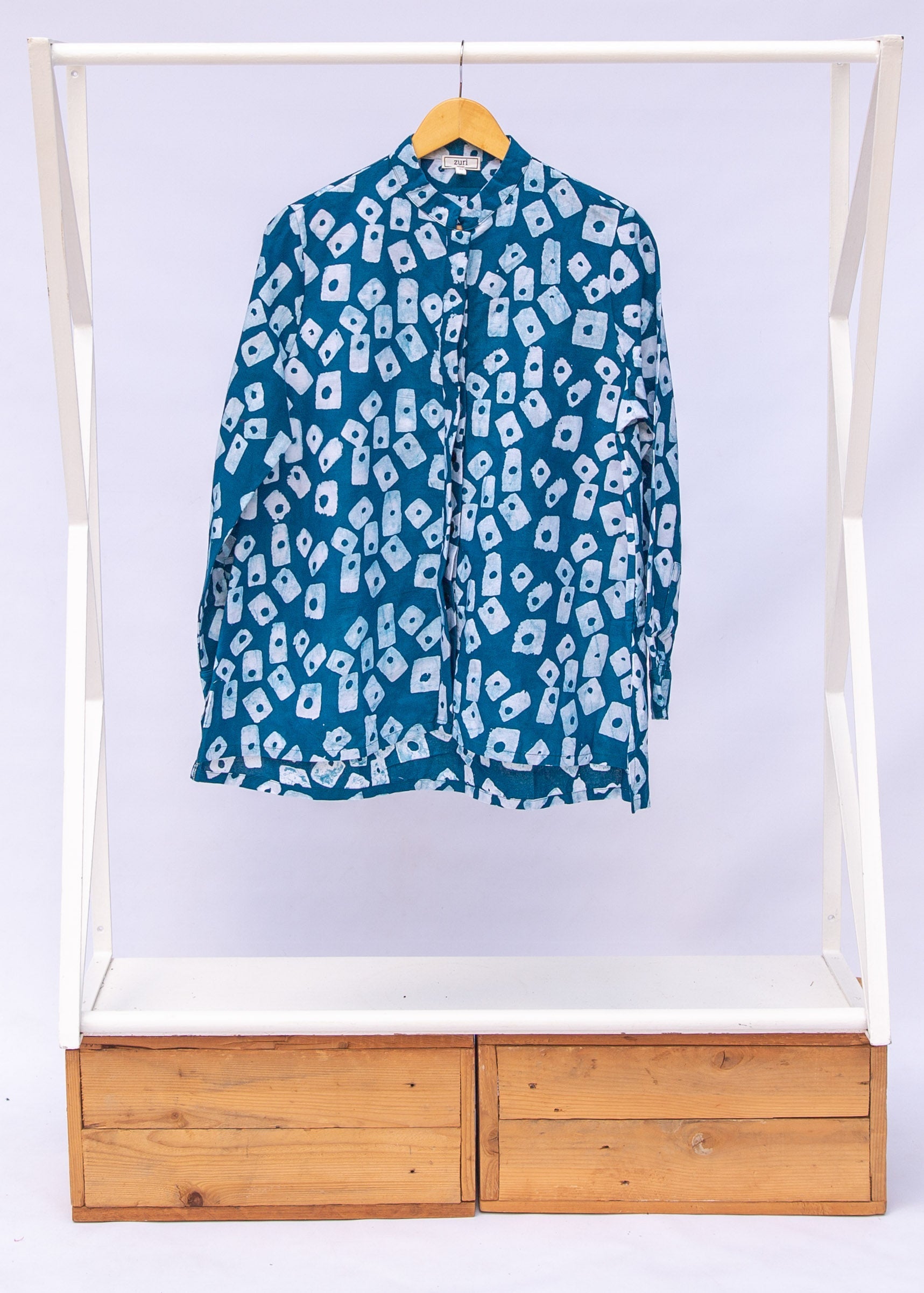 Display of blue, white domino print shirt.