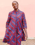 model wearing a blue, red and lavender geometric shirt dress