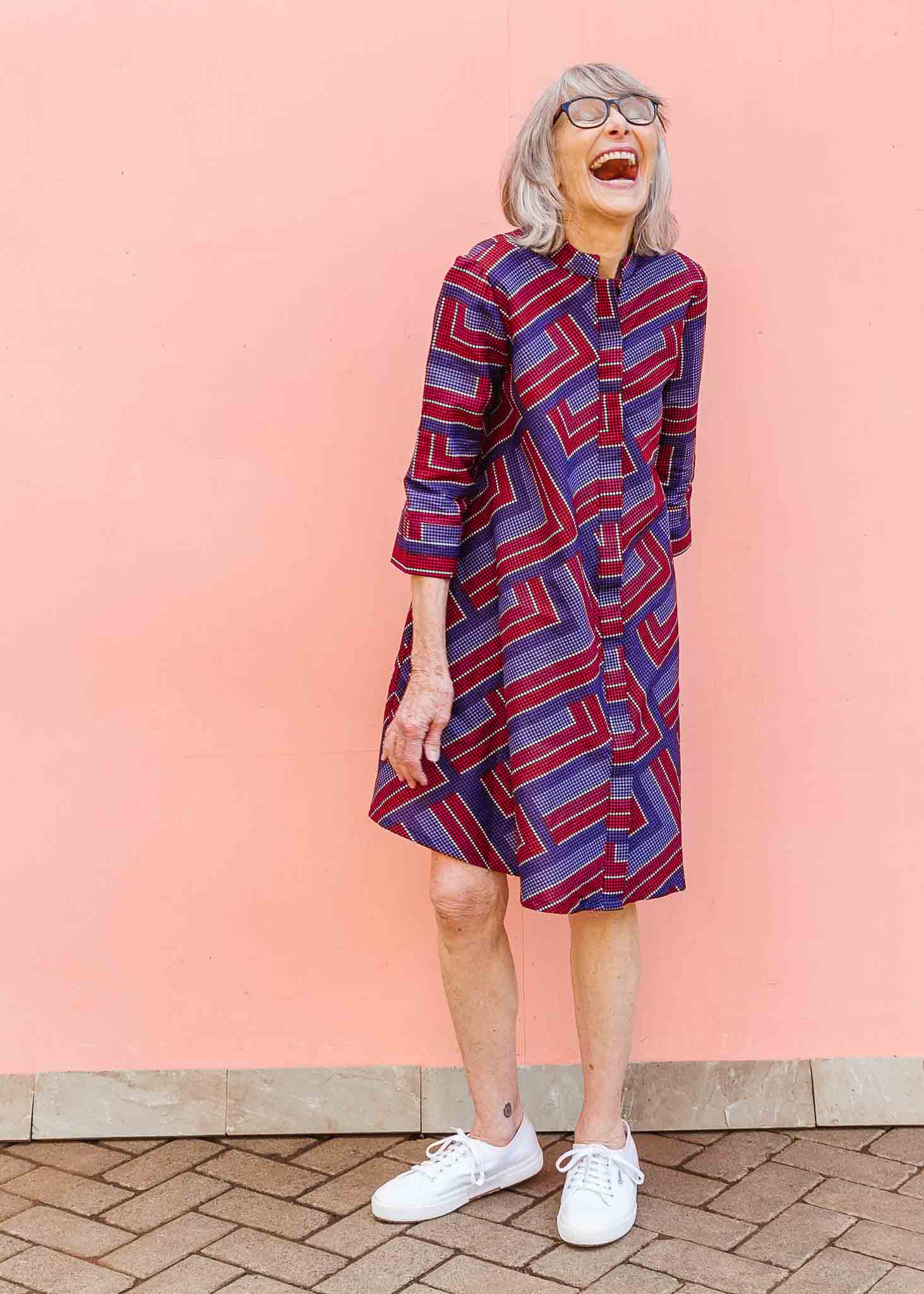 model wearing a blue, red and lavender geometric shirt dress