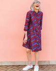 model wearing a blue, red and lavender geometric shirt dress