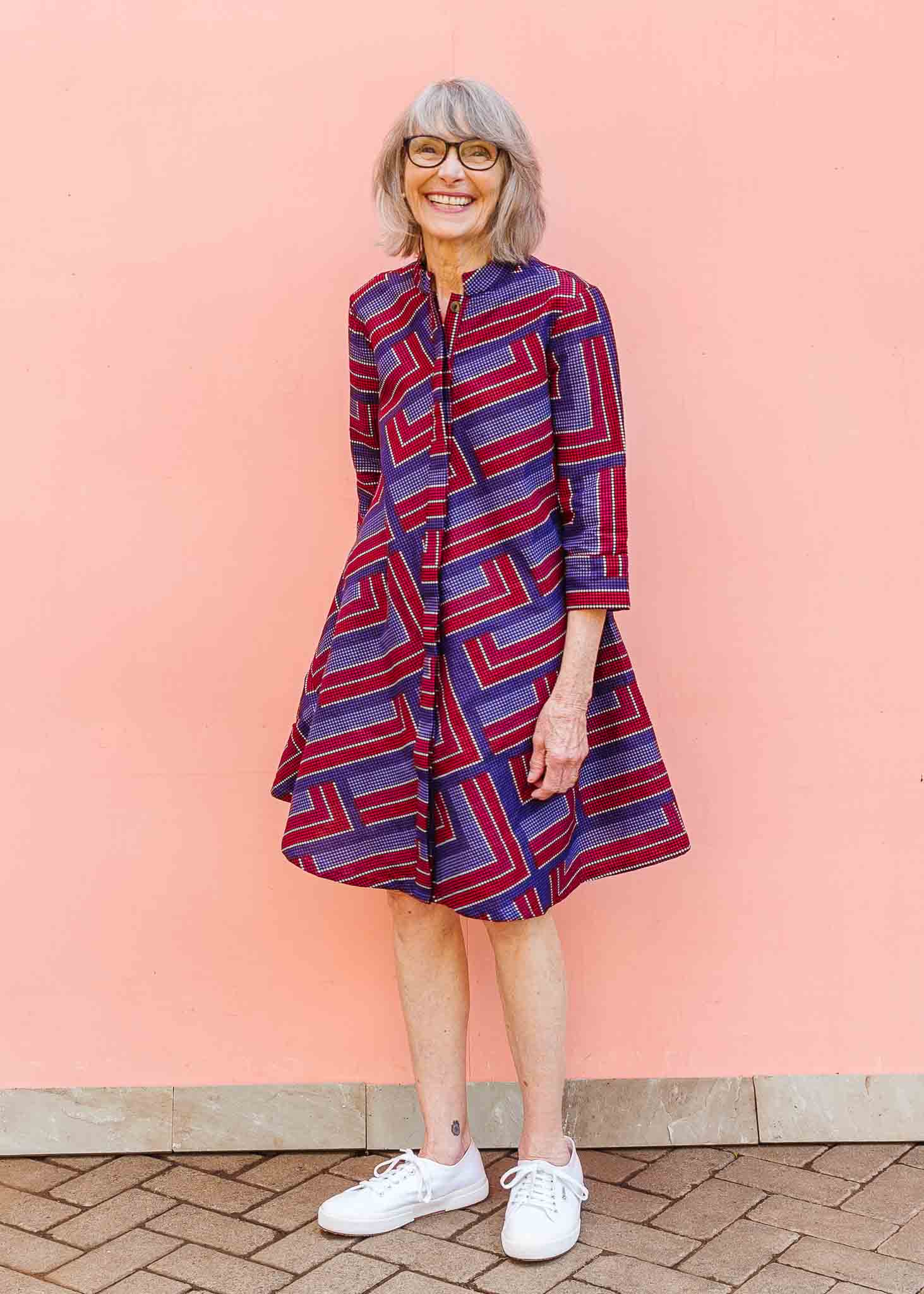 model wearing a blue, red and lavender geometric shirt dress