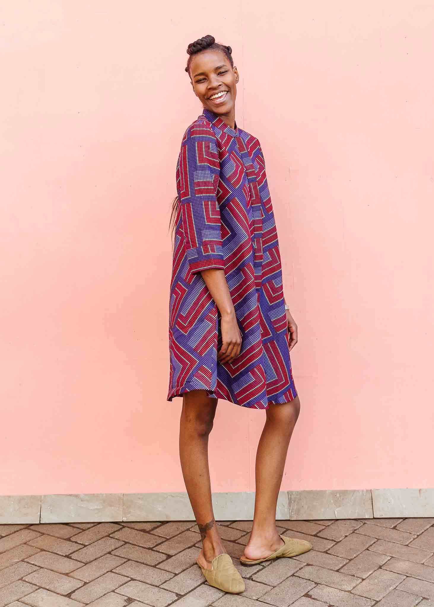 model wearing a blue, red and lavender geometric shirt dress