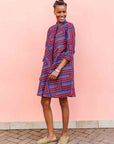 model wearing a blue, red and lavender geometric shirt dress