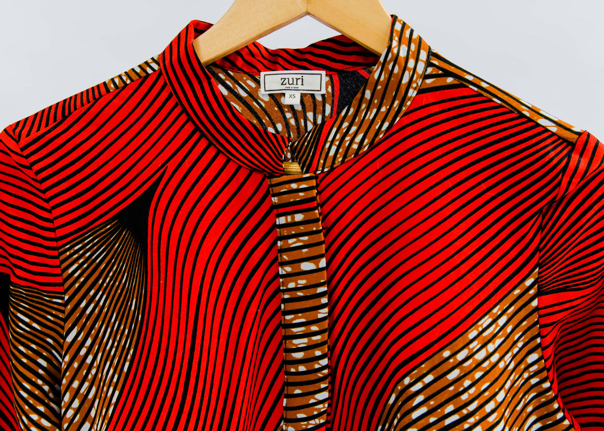 Display of red and brown abstract print dress.