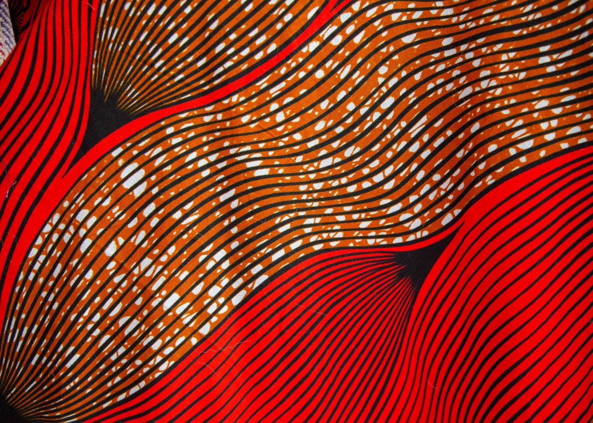 Display of red and brown abstract print dress, fabric.
