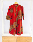 Display of red and brown abstract print dress.