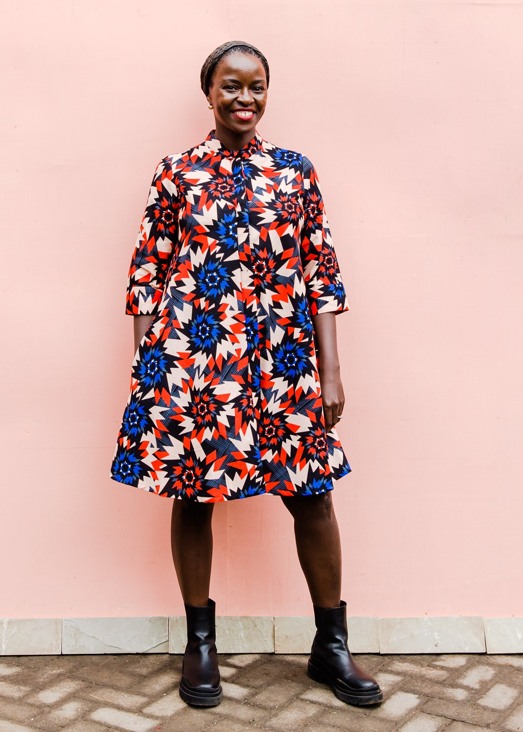 model wearing a colorful geometric shirt dress with a pinwheel design